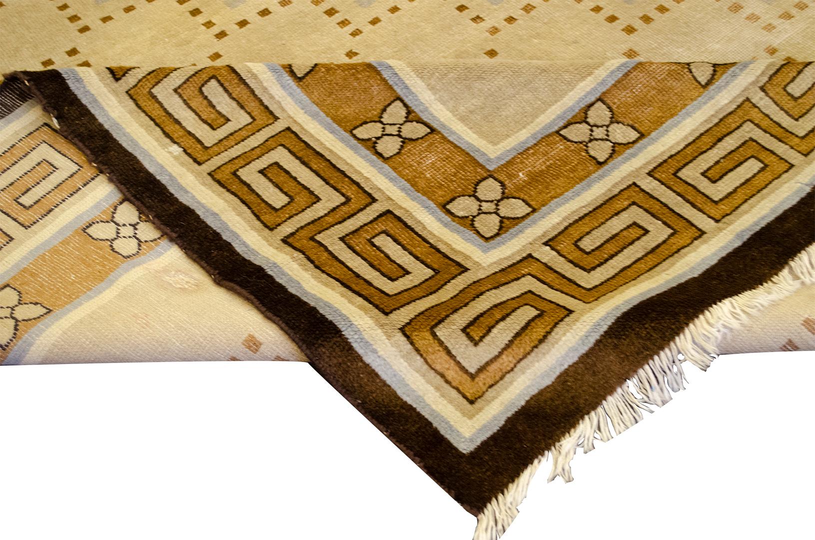 This traditional handwoven Chinese Deco rug has a beige field with dashed mole brown rectangles with periwinkle accents, in a broad traditional Chinese key pattern border, between line stripes.