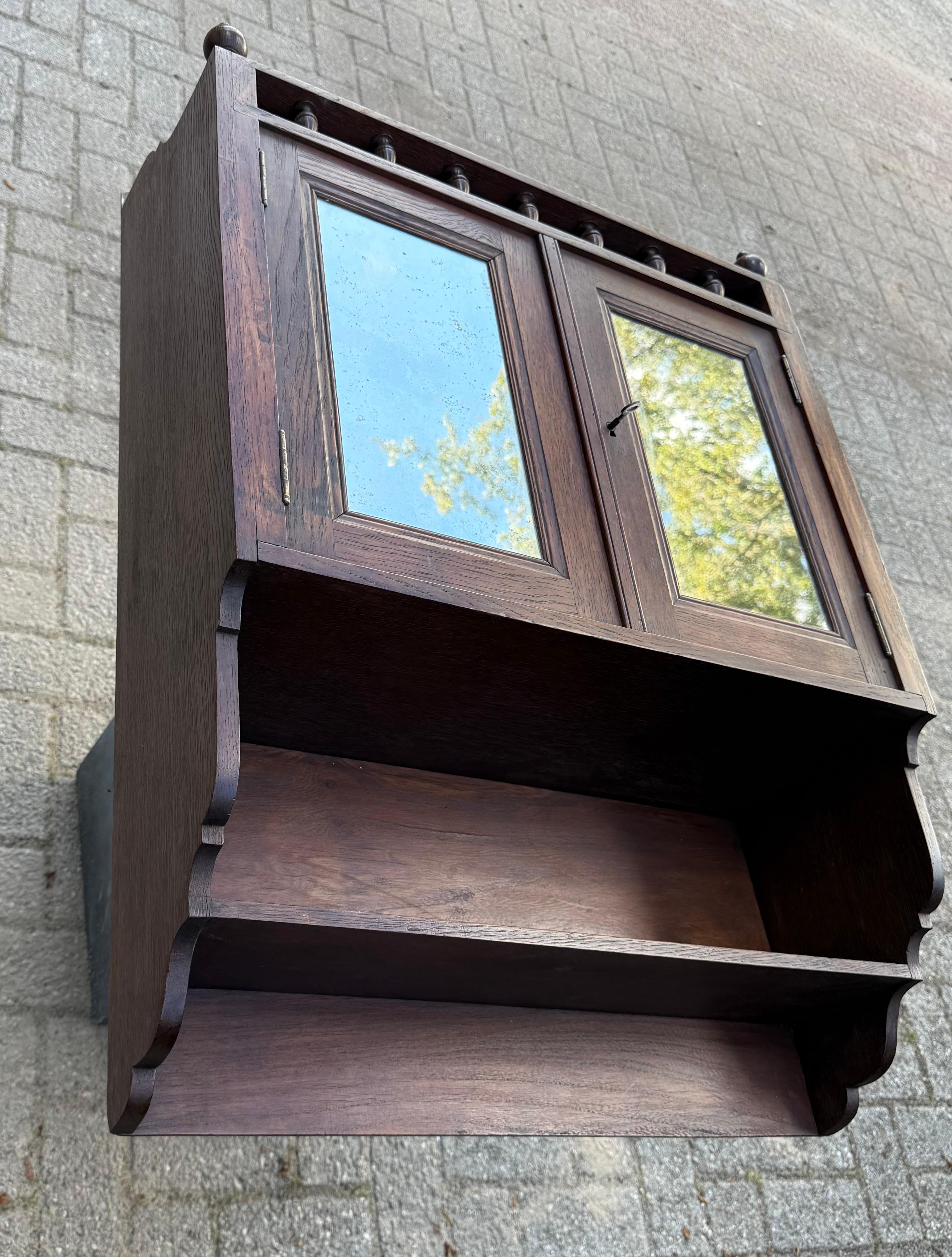 Questo straordinario armadio a muro artigianale dei primi del Novecento è un bellissimo esempio di artigianato tradizionale e design senza tempo. Realizzato in rovere massiccio con una patina ricca e calda, questo mobile combina eleganza e