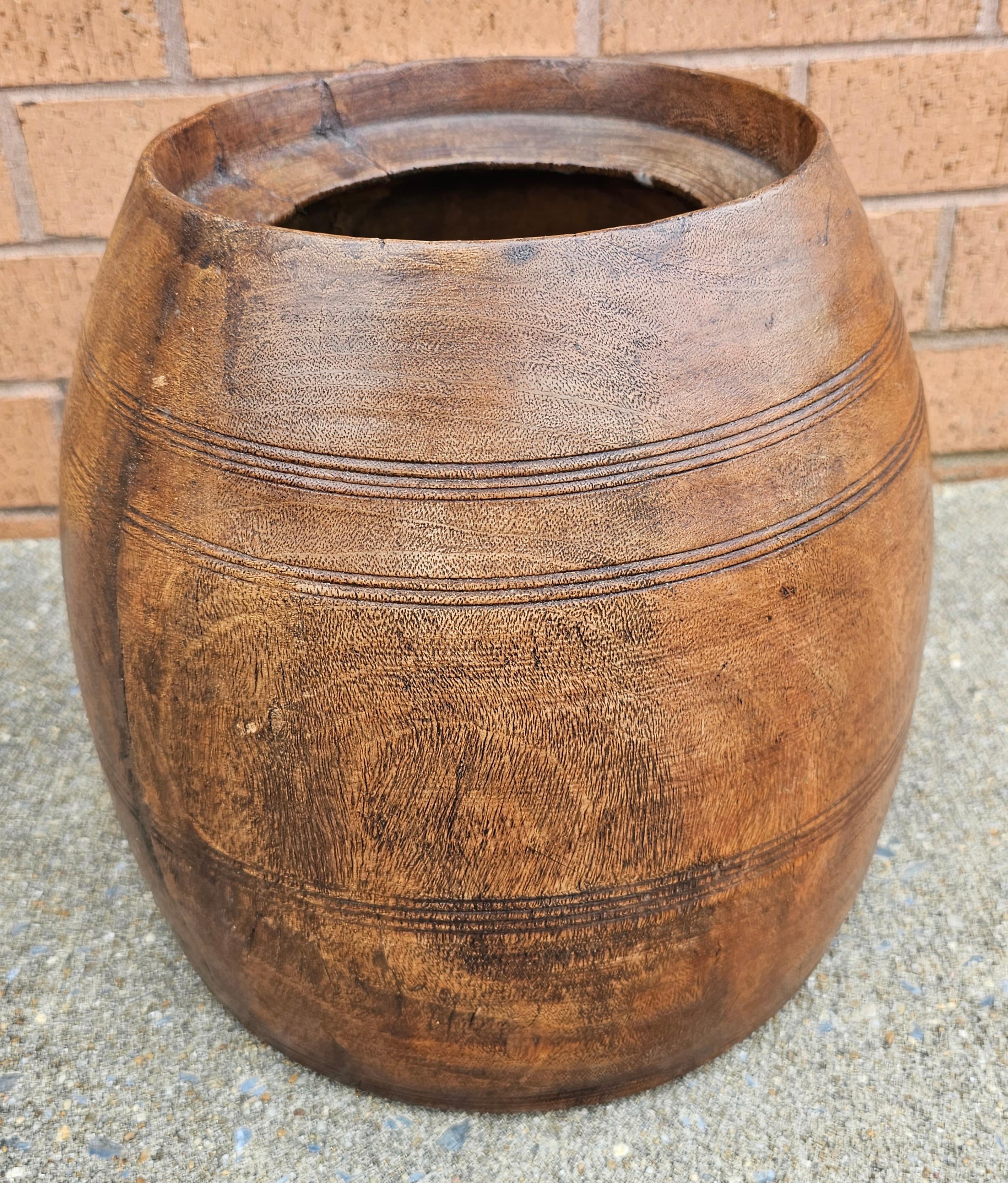 Un pot à miel ou à riz en bois tourné du début du 20e siècle, aujourd'hui utilisé comme jardinière. Une pièce unique pour apporter de l'originalité et de la visibilité à votre plante. Mesure 11