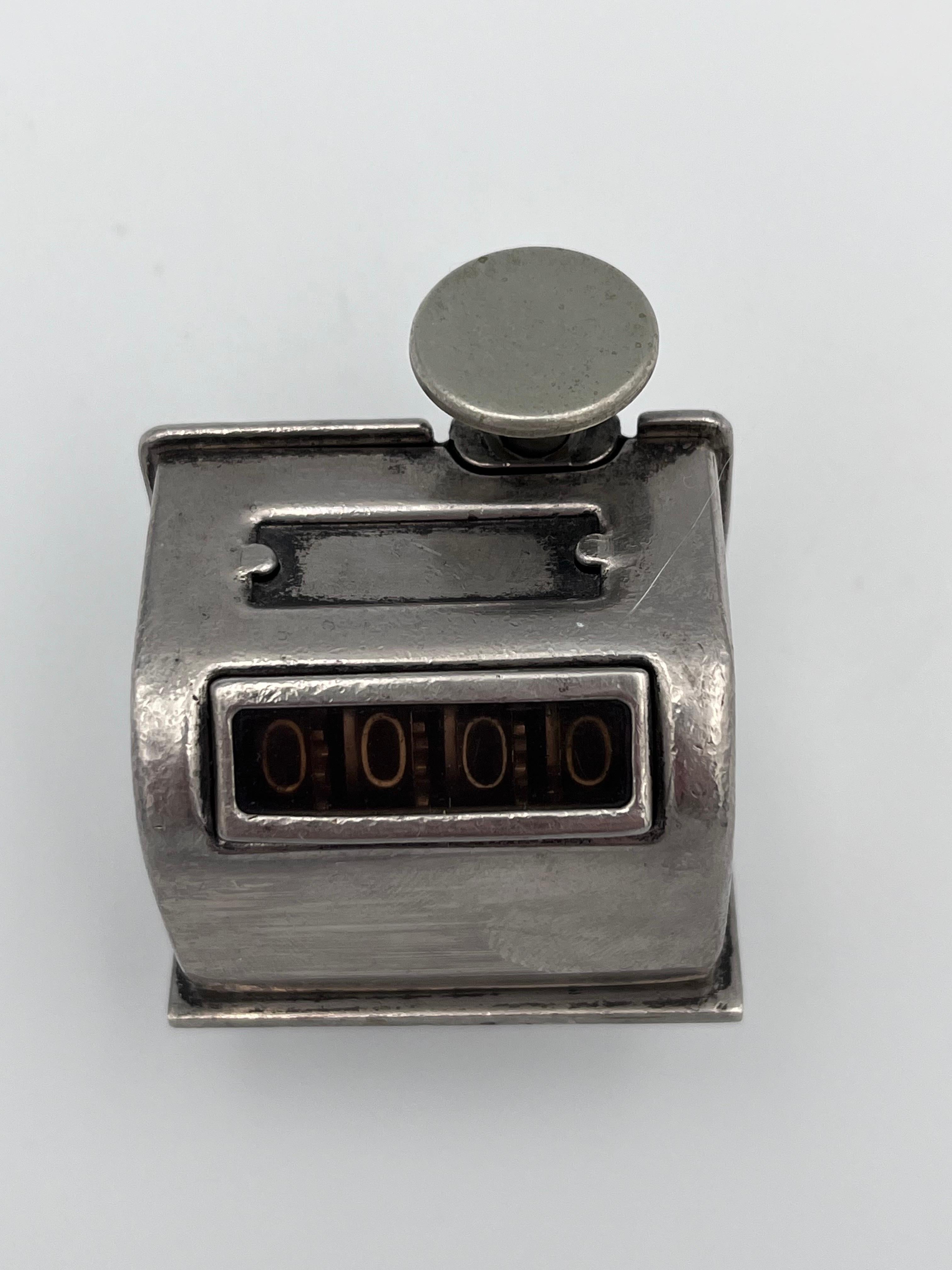 Compteur à main en laiton nickelé du début du 20e siècle, design Streamline de l'âge de la machine

Ce compteur de chiffres à main du début du 20e siècle combine le style de l'âge des machines avec une mécanique satisfaisante et entièrement