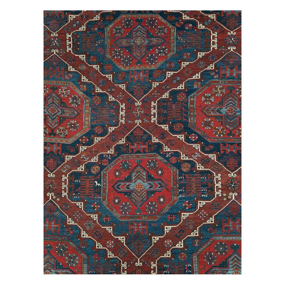 An antique Central Asian flat-weave Soumak room size carpet handmade during the early 20th century with a tribal pattern in reds, rusts, and blues. Antique Soumak rugs were generally woven on small looms and to find one this large and in this