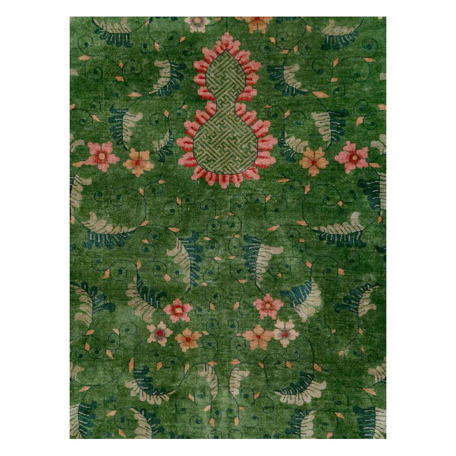 An antique Chinese Art Deco room size carpet handmade during the early 20th century with a floral pattern over an open green field and border.

Measures: 9' 1