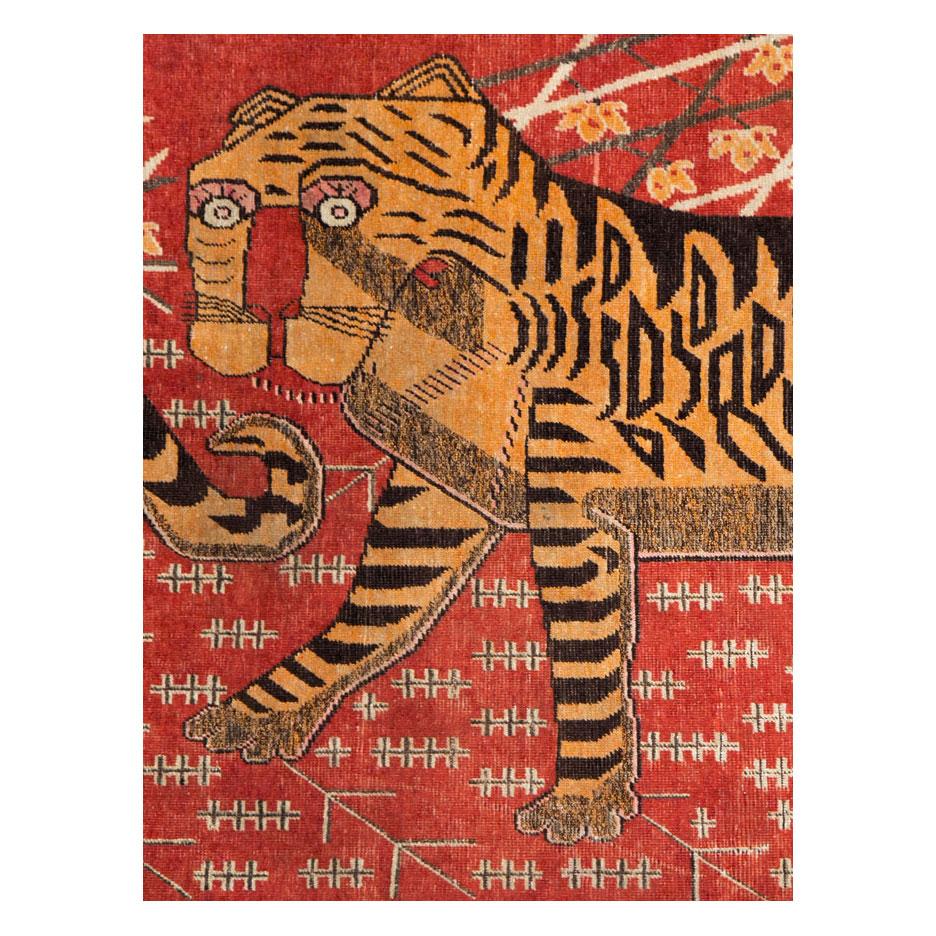 An antique East Turkestan Khotan gallery format rug handmade during the early 20th century with a pictorial depiction of two quirky tigers.