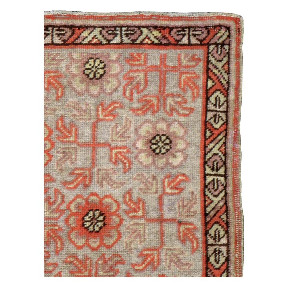 An antique East Turkestan Khotan 2' x 3' scatter/throw rug handmade during the early 20th century in shades of coral and grey.