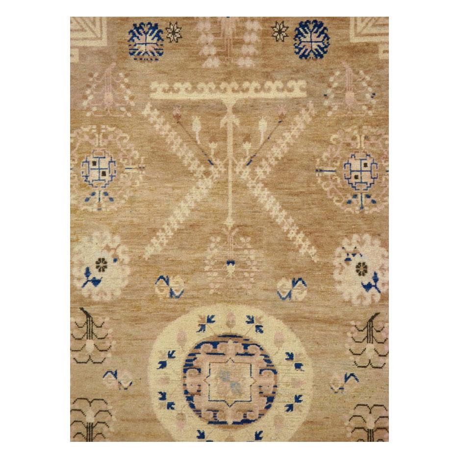 An antique East Turkestan Khotan gallery rug handmade during the early 20th century with a predominately light brown neutral field.

Measures: 5' 0