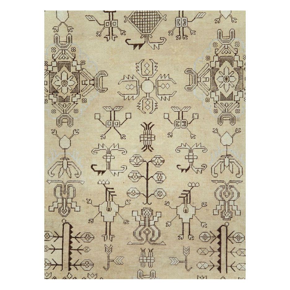An antique East Turkestan Khotan room size rug handmade during the early 20th century with a beige background. The designs are outlined in brown and some grey tones as well.

Measures: 9'3