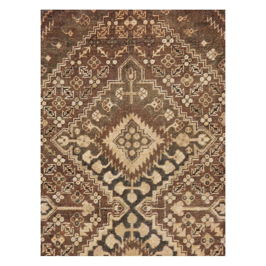 Ein antiker Khotan-Teppich aus Ostturkestan, der zu Beginn des 20. Jahrhunderts handgeknüpft wurde und hauptsächlich aus Bitonal in Brauntönen besteht. Die kleinen elfenbeinfarbenen Motive setzen einen kleinen Akzent in einer überwiegend neutralen