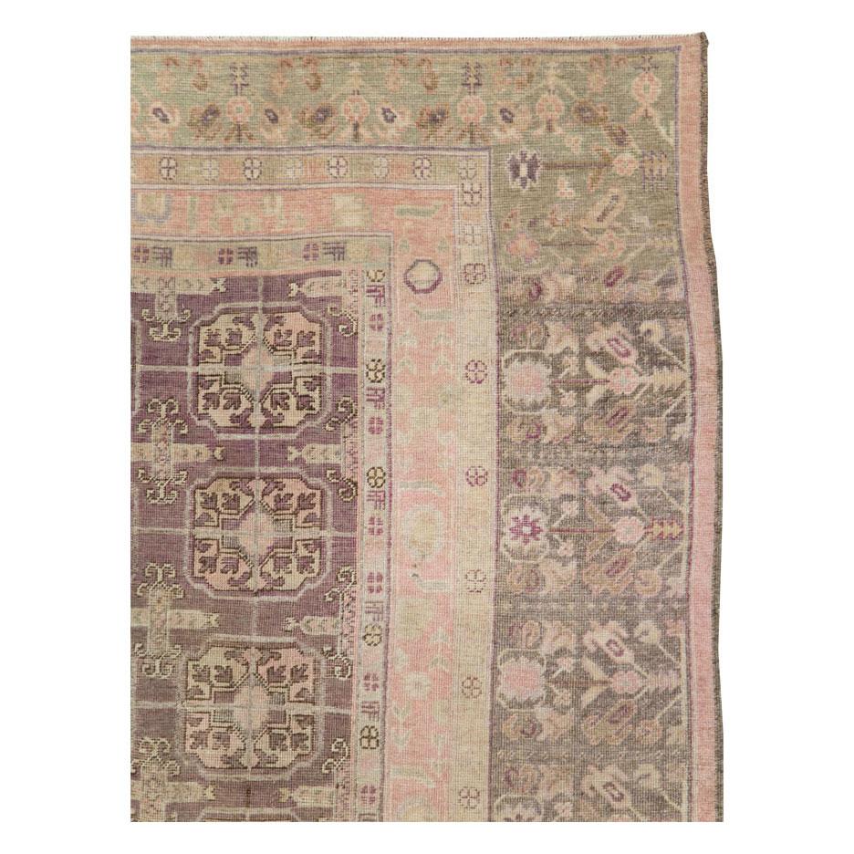 An antique East Turkestan Khotan square room size carpet handmade during the early 20th century in shades of khaki green and aubergine purple.

Measures: 8' 8