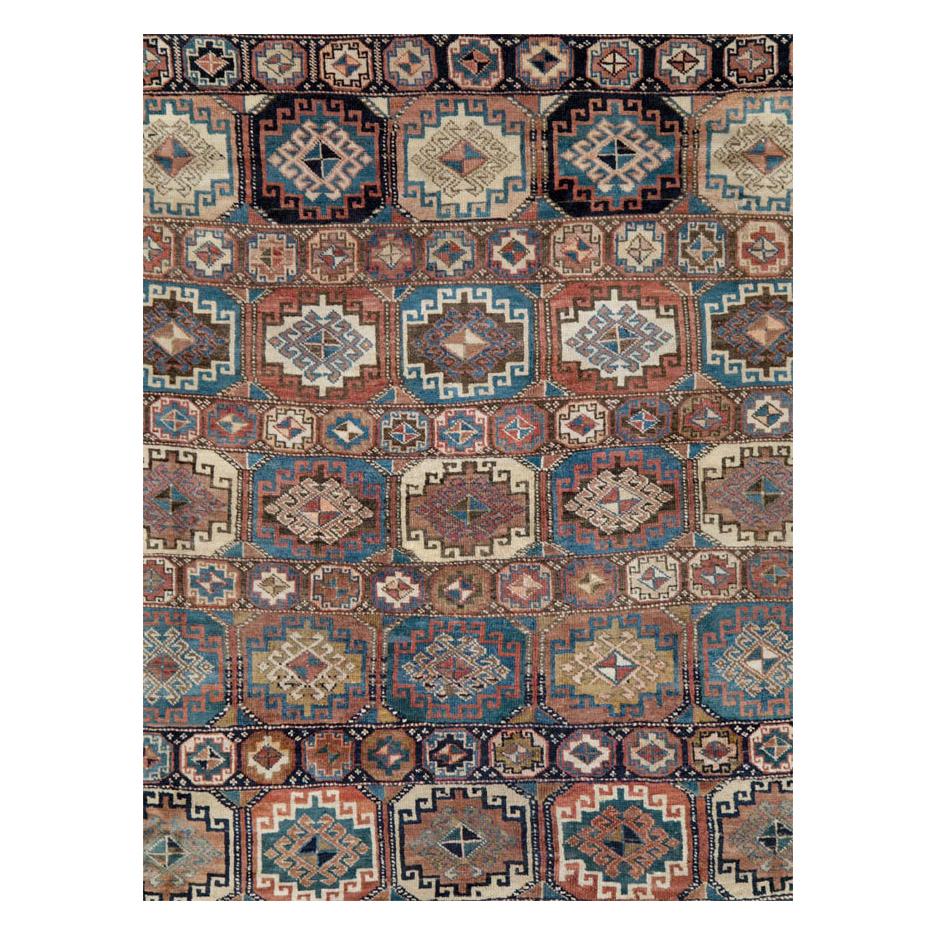 An antique Persian room size carpet from the Northwest Persian region handmade during the early 20th century with a geometric tribal design enclosed by a 'turtle palmette' border.

Measures: 8' 0
