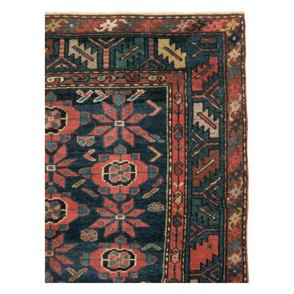 A vintage Persian Malayer accent rug handmade during the early 20th century with a dark blue field, green border, and floral motifs in a light red tone.

Measures: 3' 9
