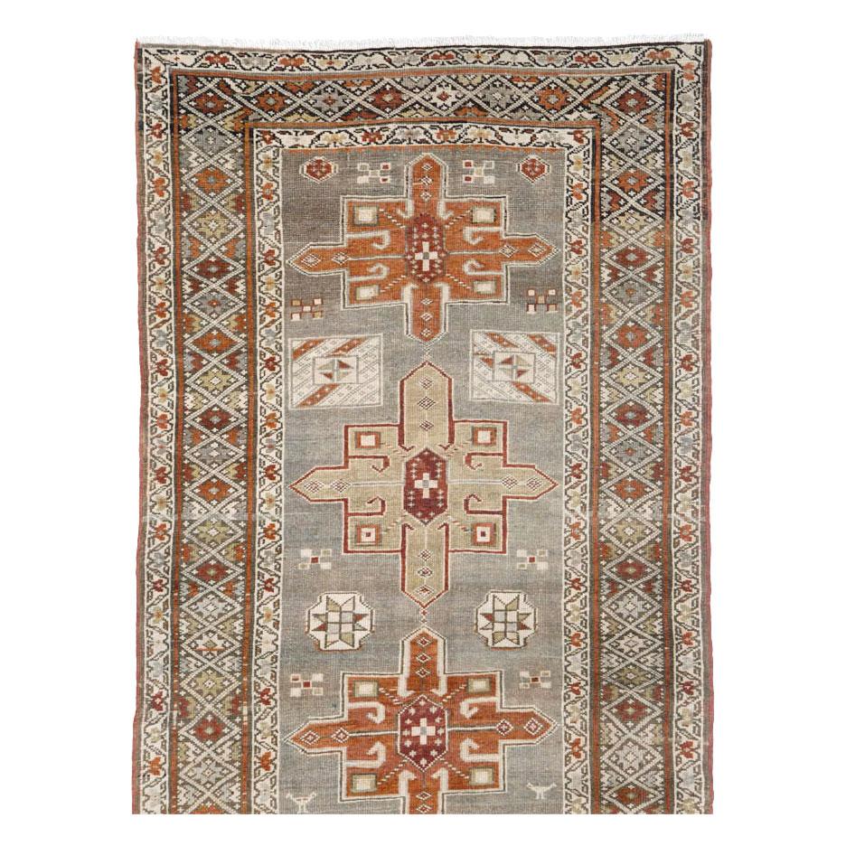 An antique Persian Heriz long rug in runner format handmade during the early 20th century.

Measures: 3' 4