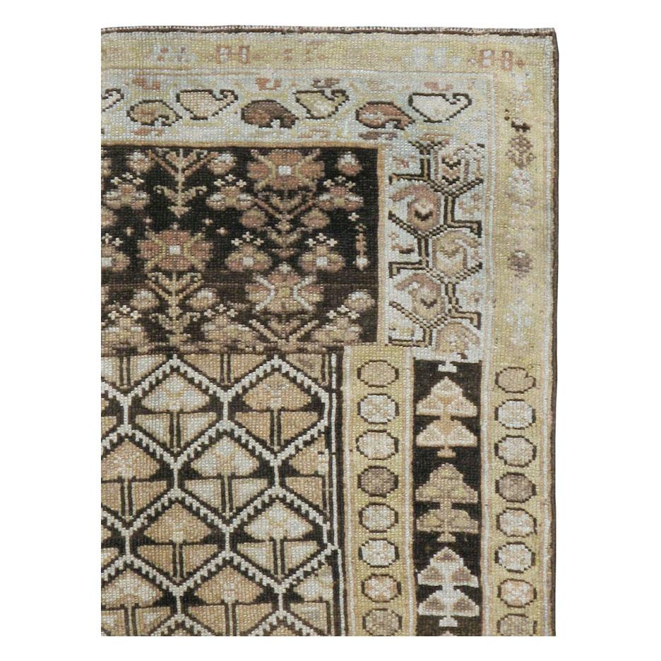 An antique Persian rug in runner format in earth tones handmade during the early 20th century by the Kurdish tribes in Persia. This unique piece shows the genuineness and the creativity of tribal rugs. The weavers seemed to begin one pattern before