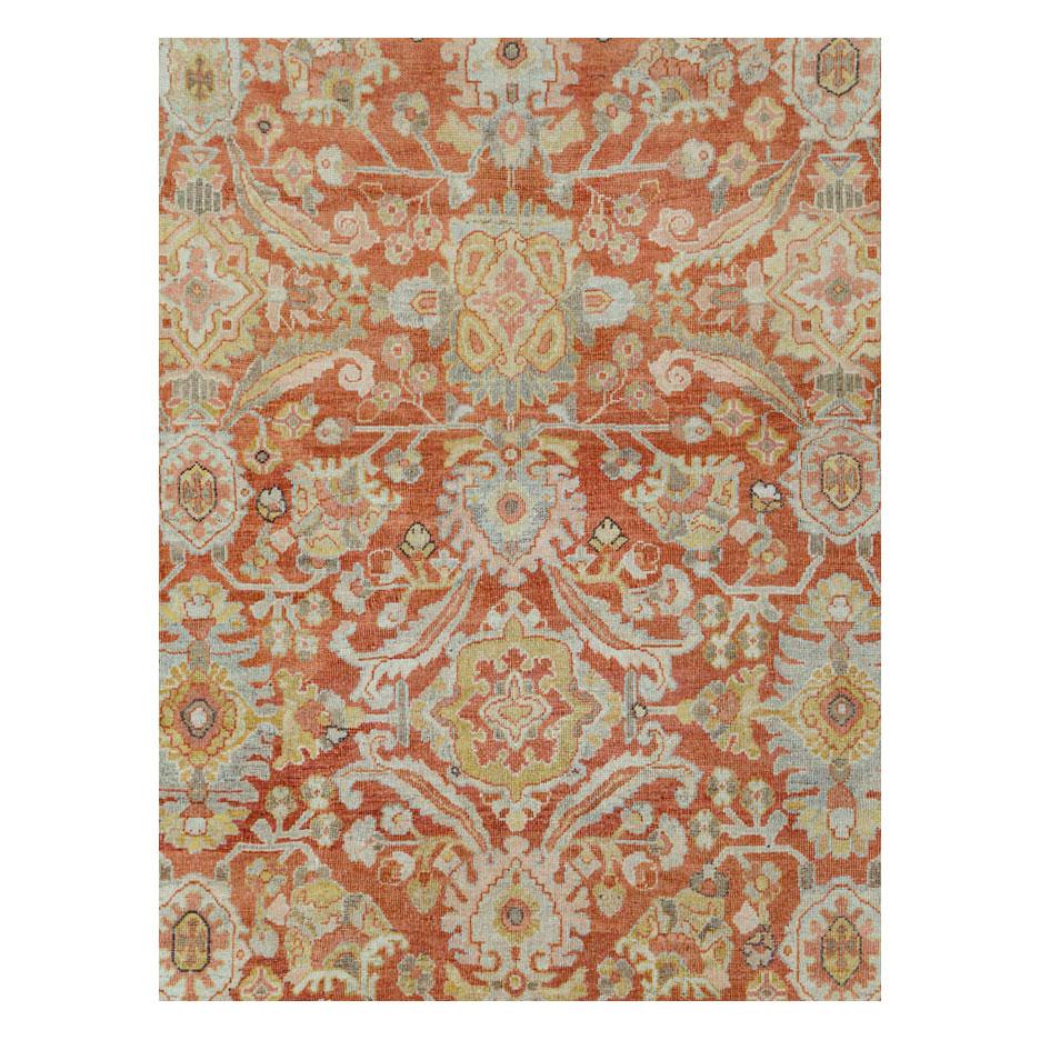 An antique Persian Mahal room size carpet handmade during the early 20th century with a rust red field and a lightly abrashed (natural horizontal color variations) slate grey to light blue border.

Measures: 9' 1
