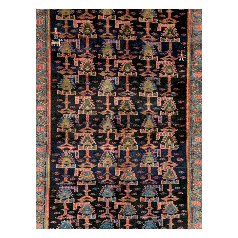 An antique Persian Kurd Bidjar tribal accent rug in gallery format handwoven by the Kurdish tribes in Persia during the early 20th century primarily in rich jewel tones including navy blue and red.

Measures: 5' 0
