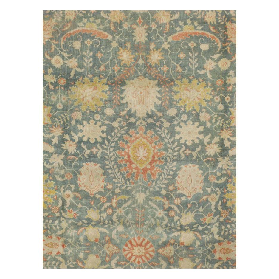 An antique Turkish Oushak large room size carpet handmade during the early 20th century with a predominantly blue-green field.

Measures: 11' 4