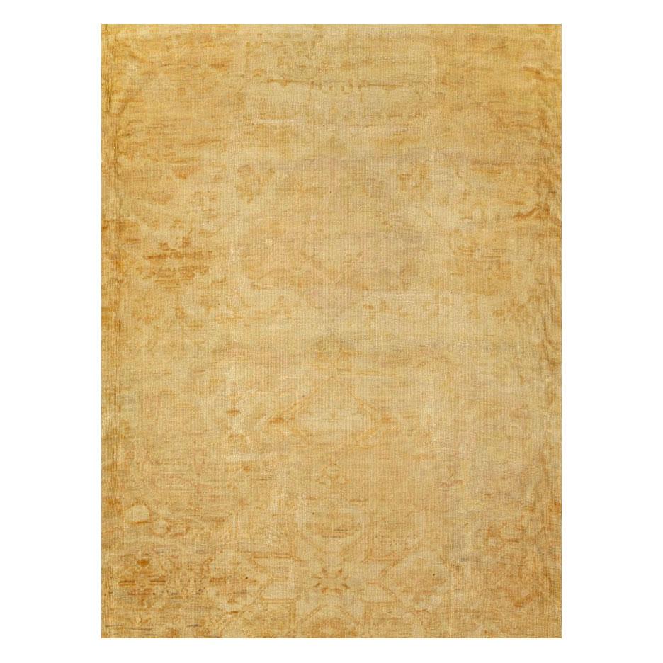 Un tapis turc antique Oushak de grande taille pour une pièce, fabriqué à la main au début du 20e siècle dans des tons dorés et beiges.

Mesures : 12' 10