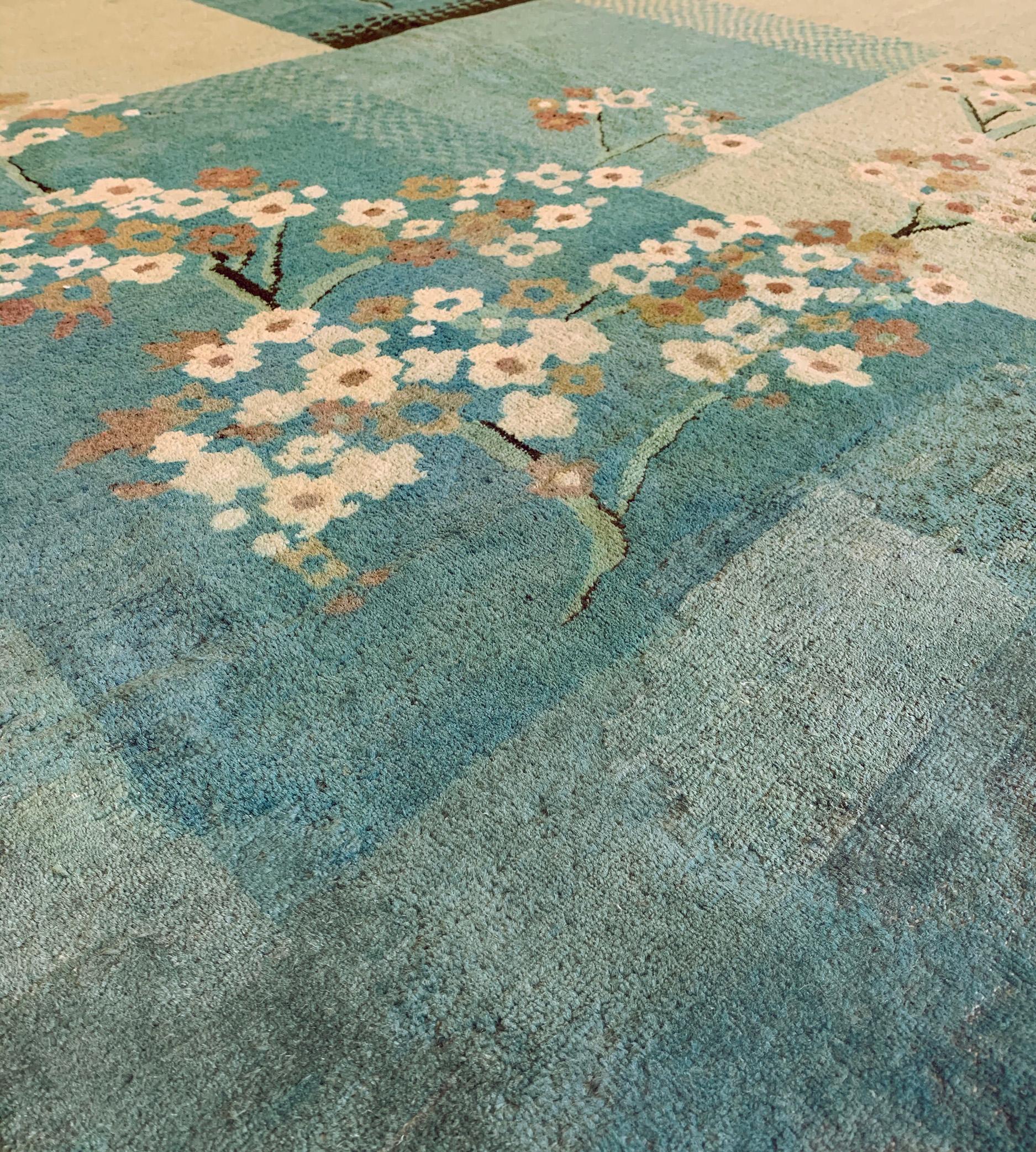 This traditional handwoven Chinese Deco rug has soft minty blue and ivory cream fields of shaded cells issuing refined hexagonal graded transitions, overlaid by elegant scrolling cherry blossoms.

In the rug trade, the term “Deco” applies to