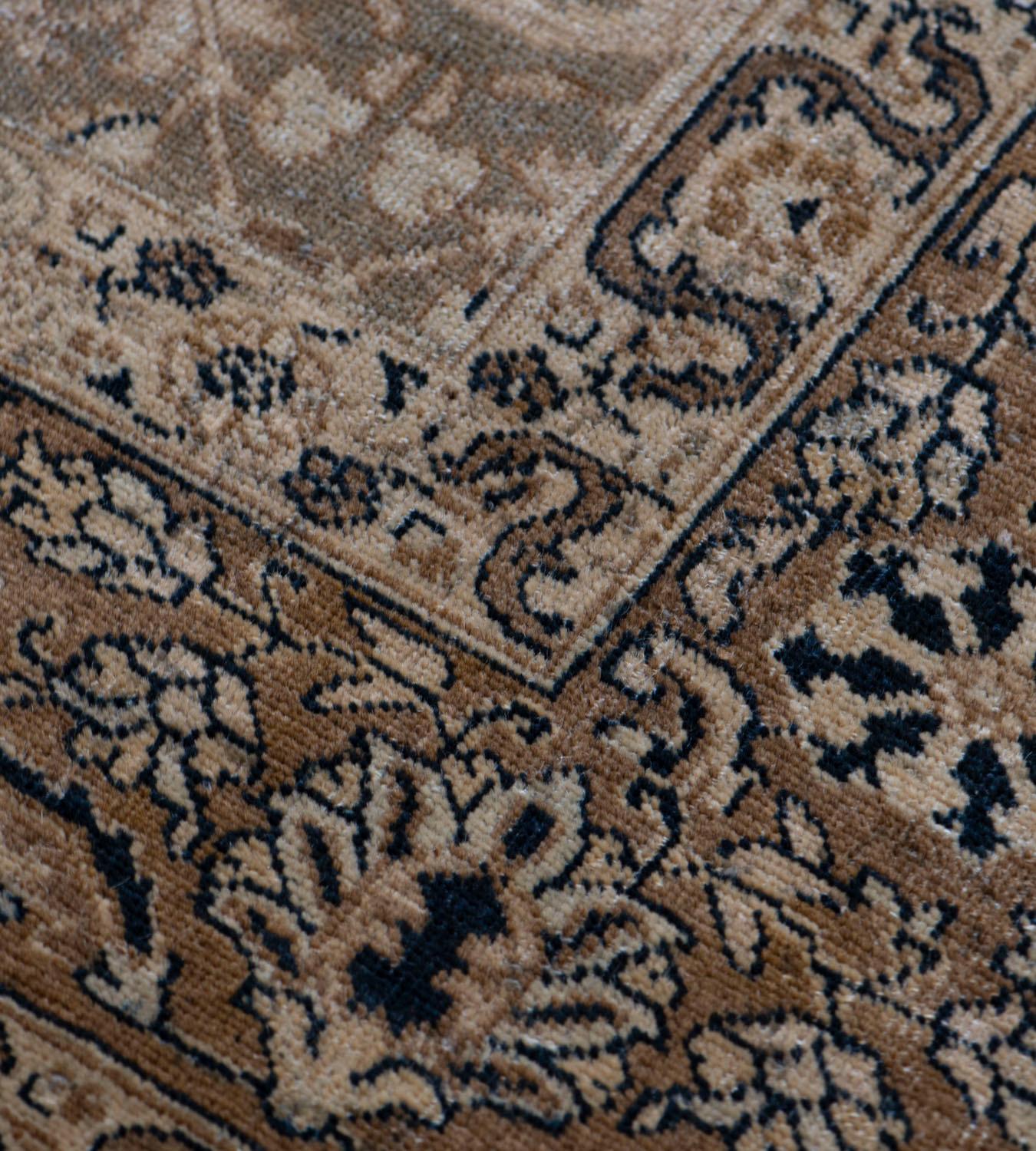 The green-grey field with an overall design of sandy-yellow, charcoal-blue and ivory delicate palmette and floral vine, in a buff-brown border of delicate palmette and floral vine between sandy-yellow floral vine stripes.