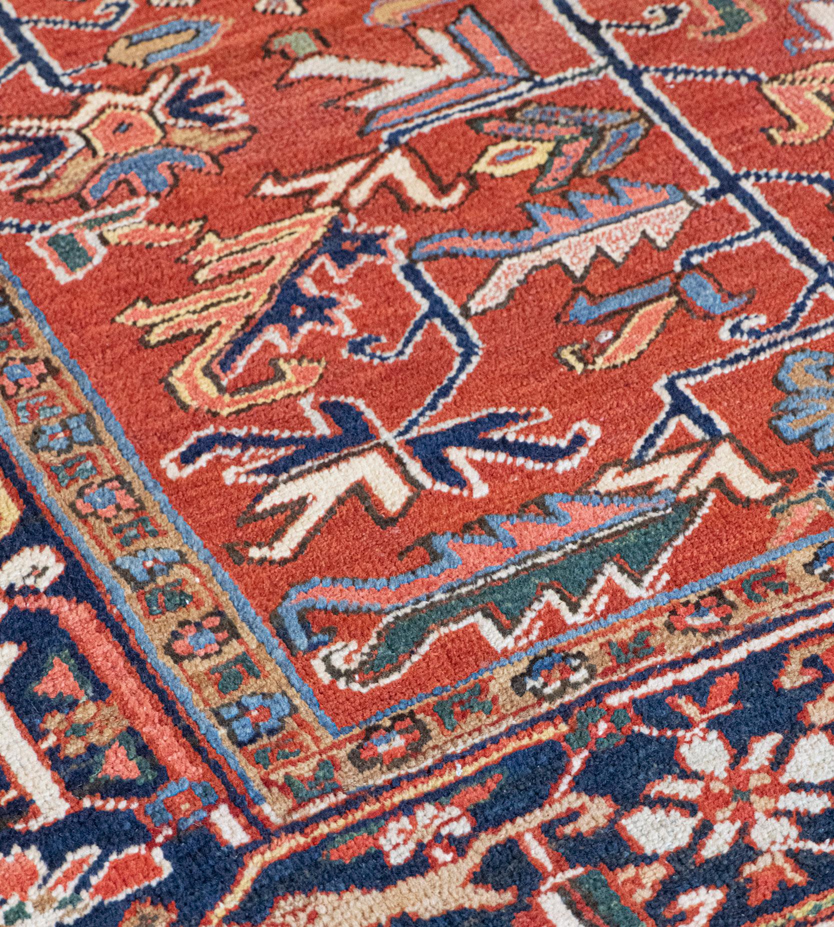 This traditional hand-woven Persian Heriz rug has a shaded brick overall field with a dense lattice of leafy angled floral vines, in a deep indigo turtle palmette border, between refined vine stripes.