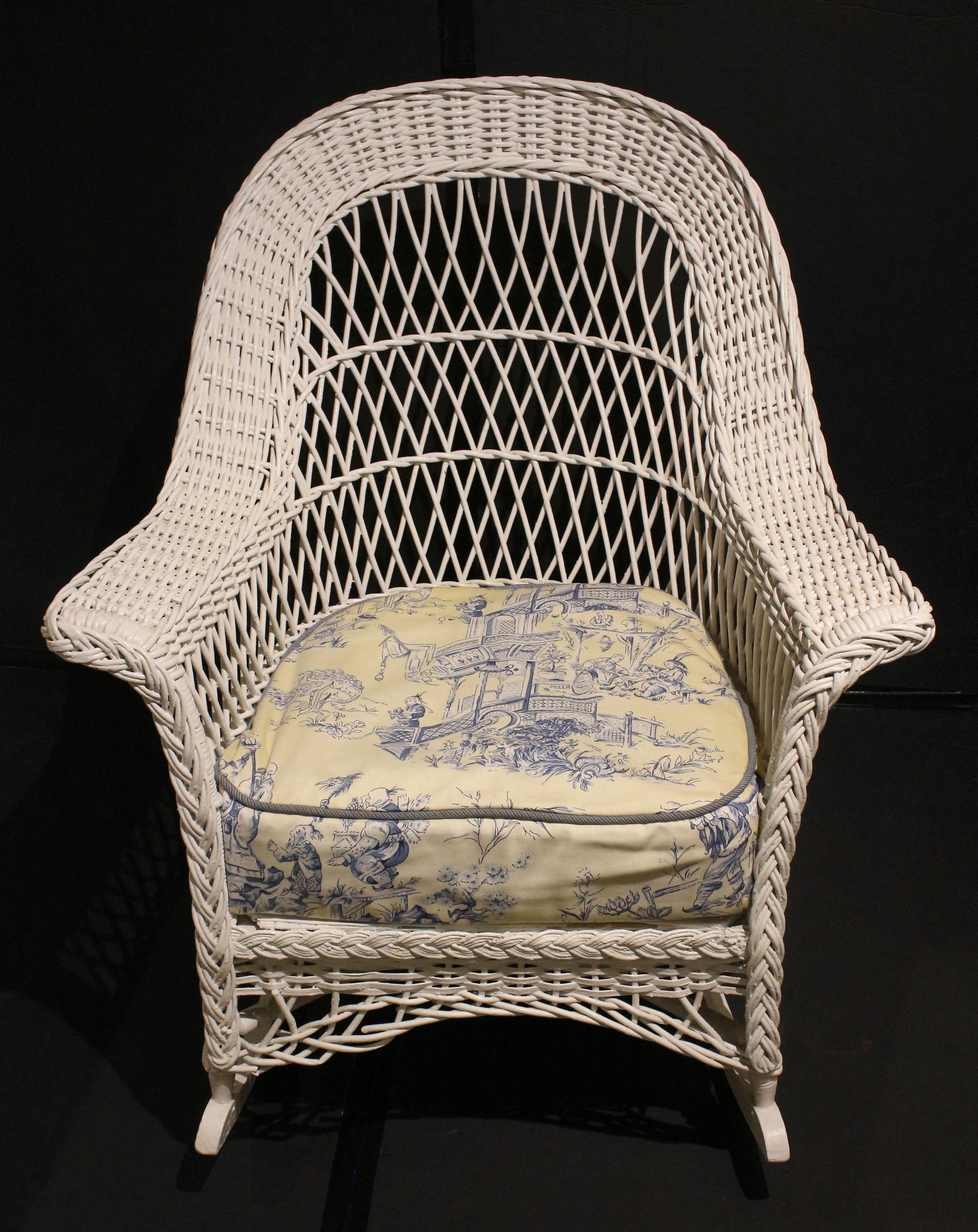 Early 20th century Heywood-Wakefield Bar Harbor wicker rocking chair. Attractively braided arms & wonderful open diamond reed-work back. Repainted. Custom toile cushion (used condition). 
30.25