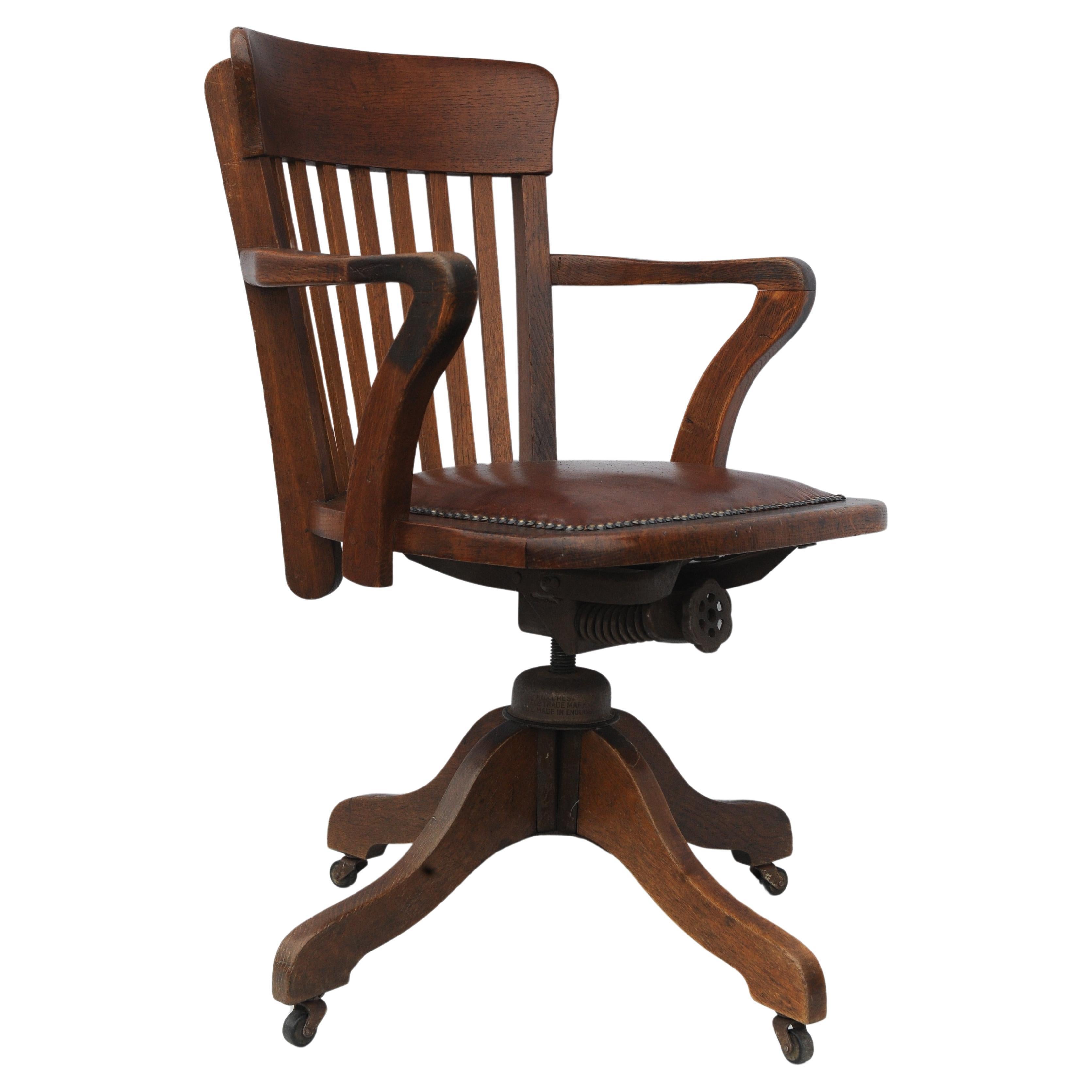 Chaise de bureau pivotante en chêne Hillcrest du début du XXe siècle avec assise en cuir marron poli et clous en laiton 

Fabriqué en Grande-Bretagne par la célèbre marque de chaises Hillcrest. 

Hauteur des bras 68cm
Largeur du siège