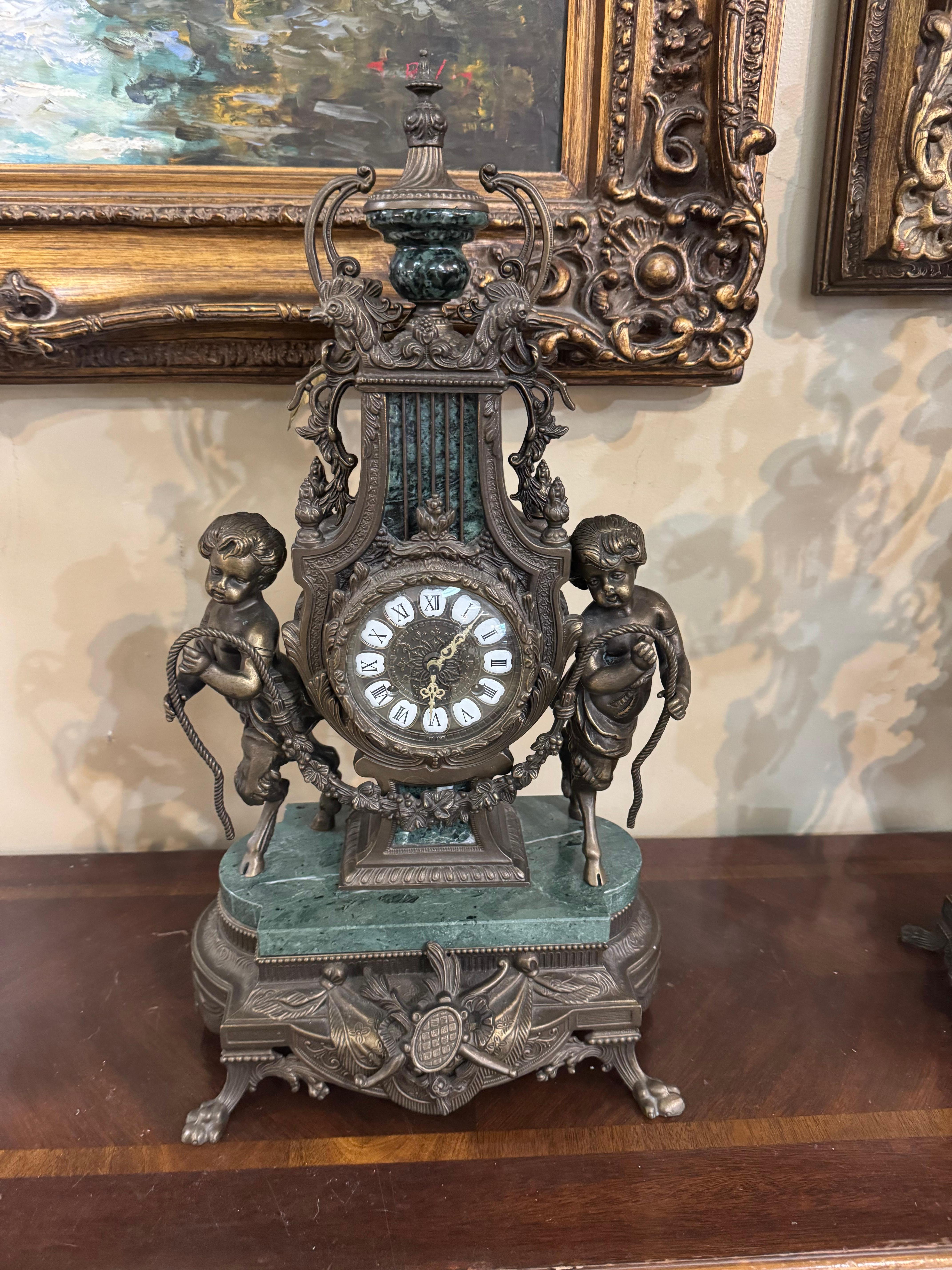 …
Description A stunning Renaissance style gilt bronze & marble clock having a lyre form case centered with patinated metal a cherub head each bearing a rope clad with a garland swag and rising on a footed lion claw gilt base. This clock has an