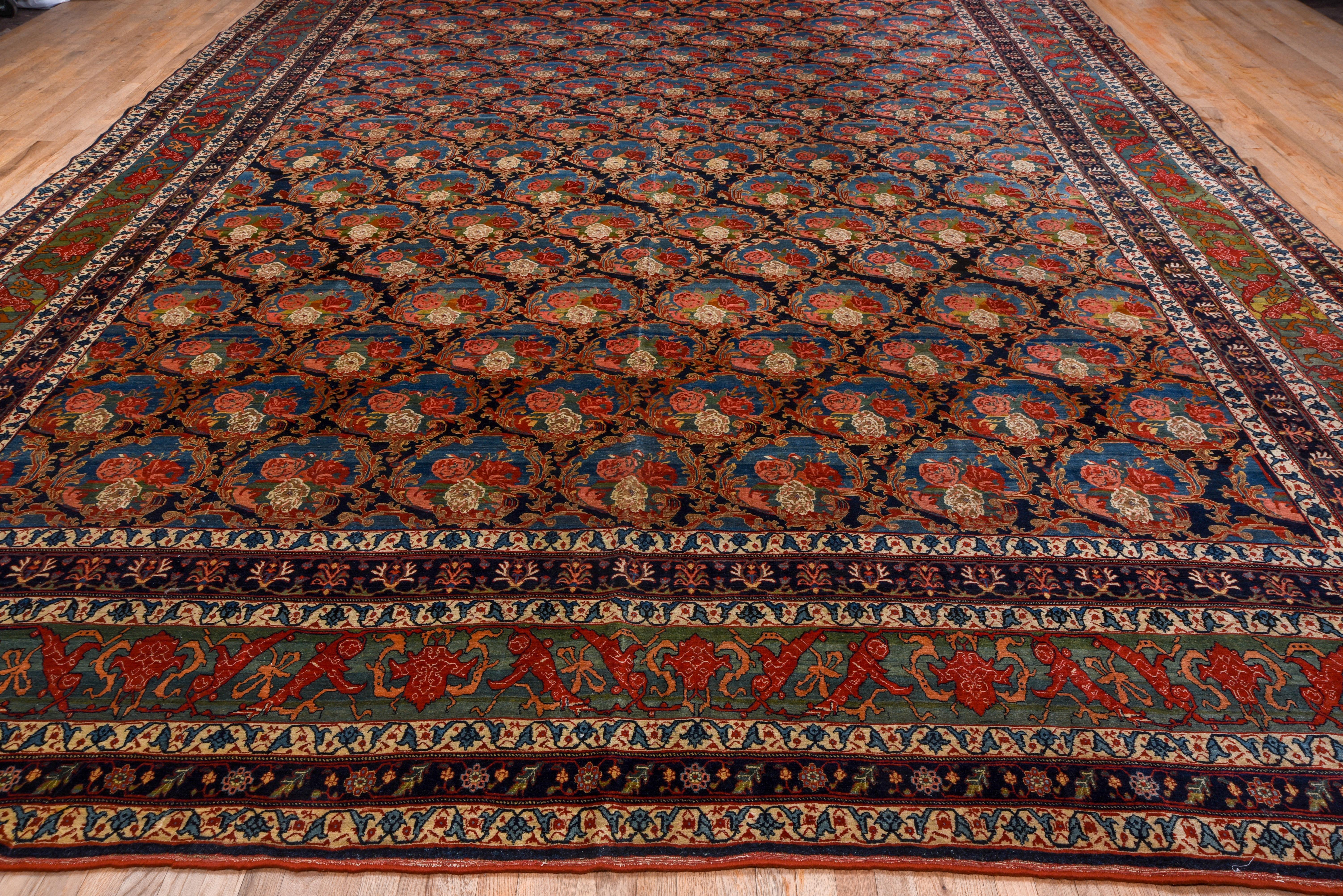 The blue-black field is covered by a Gol-i-Firangi (French floral) allover pattern of bouquets within acanthus ovals, highlighted in medium blue, red and ivory. There are seven border on this fine condition, virtually impervious NW Persian Kurdish