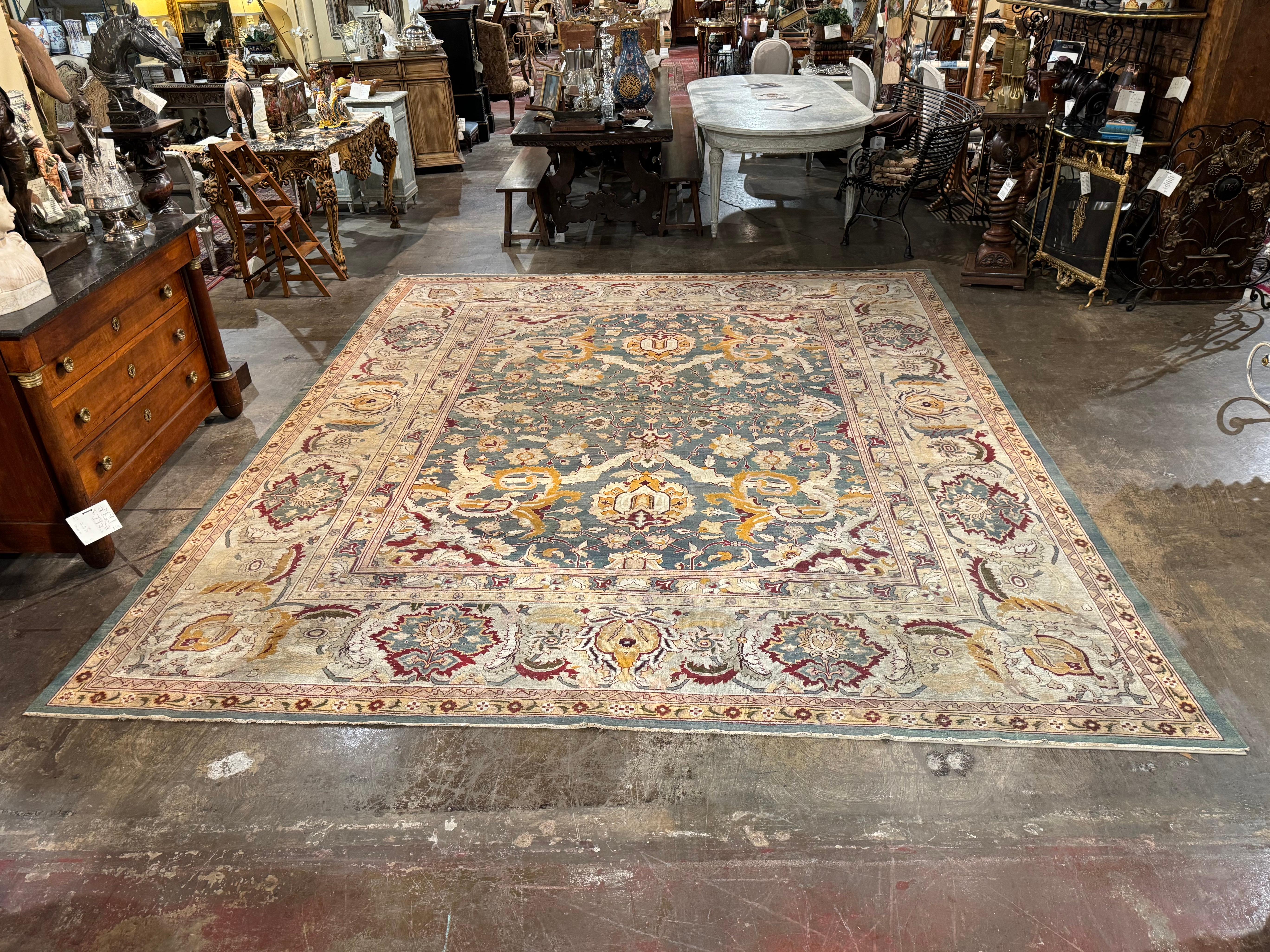 This antique oriental style rug would make a great addition to any den, living room, or dining room. Hand knotted in Agra India circa 1920, the area rug features several intricate borders, the largest featuring floral and foliage motifs throughout.