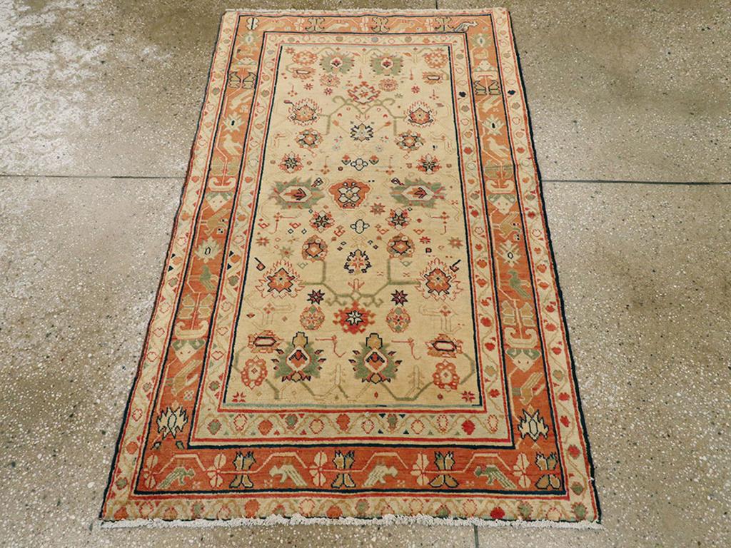 Ein antiker indischer Lahore-Teppich. Ein sandgelbes Feld zeigt ein weitläufiges Muster aus schwebenden und miteinander verbundenen Palmetten unterschiedlicher Art und Größe, alles innerhalb eines Bordürensystems mit einem hellen rostfarbenen