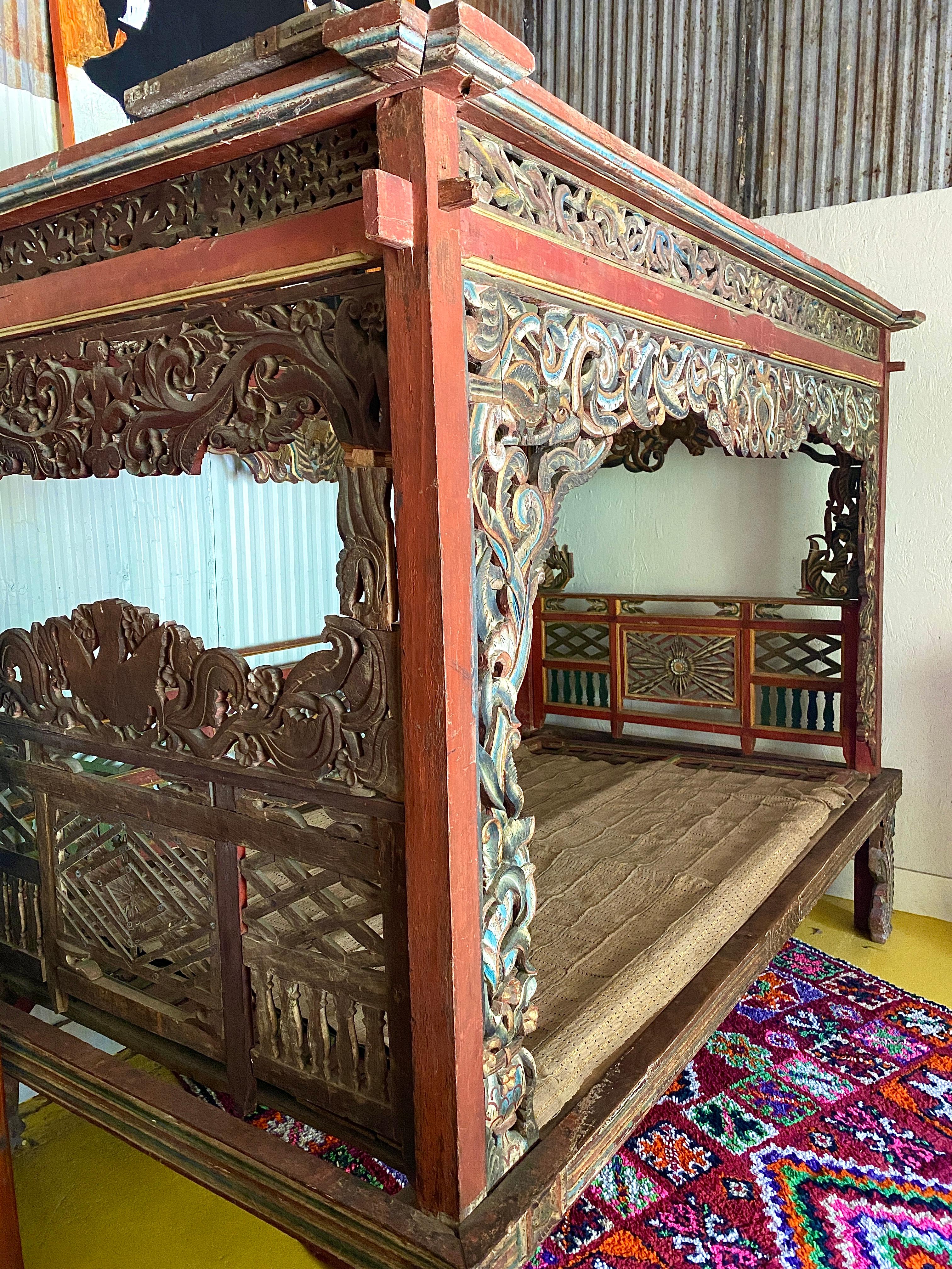This early 20th century Indonesian ceremonial wedding bed is a stunning piece for lounging as a day bed in the home or a large covered porch. The hand-carved detailing is exquisite. Because of the age use, and the impending move- the bed will need
