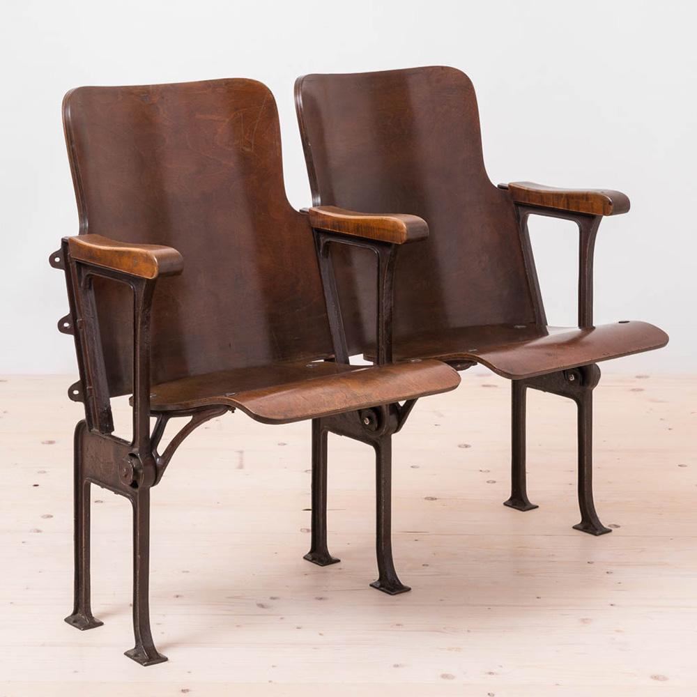 Este asiento doble plegable de principios del siglo XX presenta elementos de madera contrachapada curvada, probablemente de madera dura como el abedul. Los elementos de madera se han limpiado y repasado con aceite y cera, dándole un aspecto