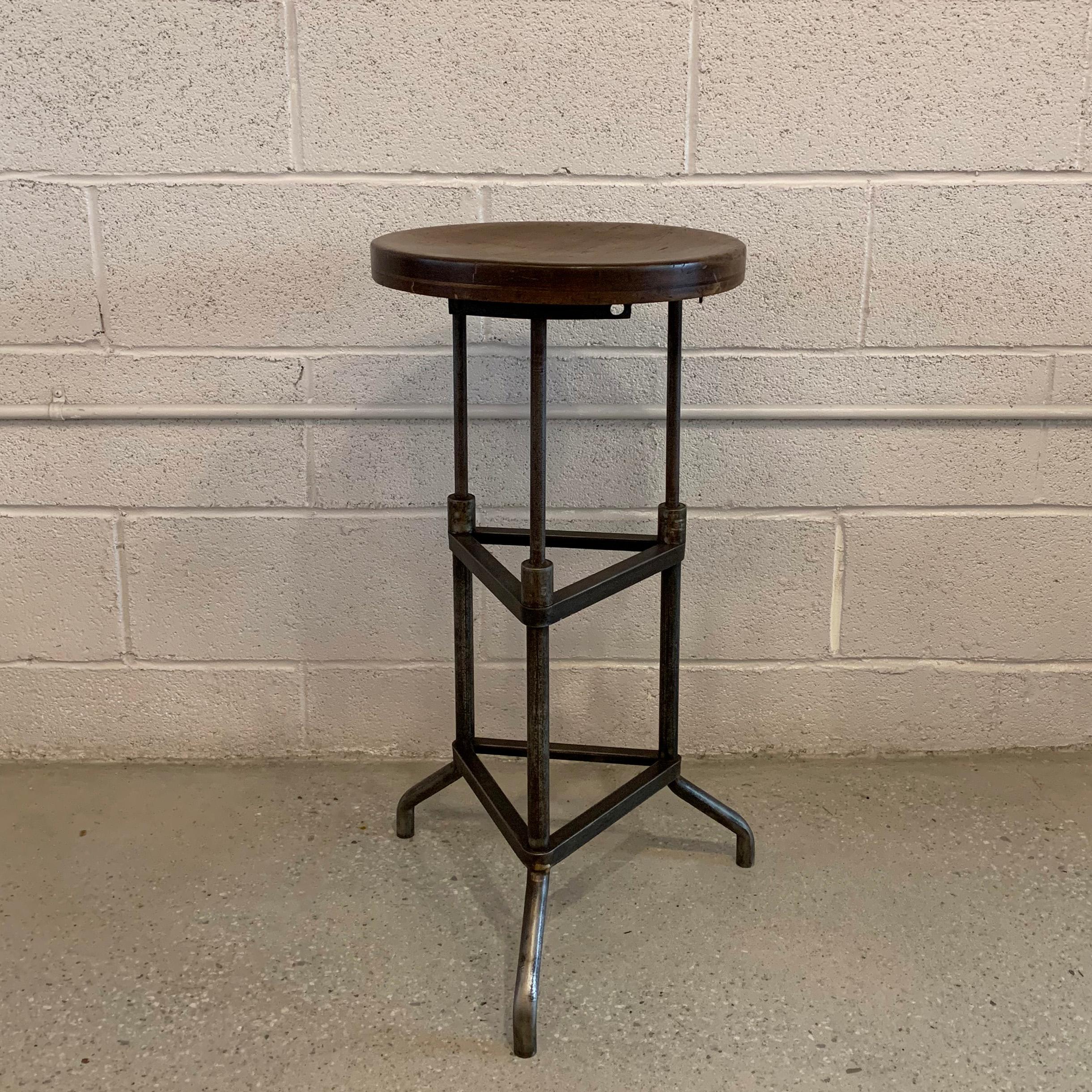Industrial, early 20th century, drafting stool features a tripod, brushed steel base with 14 inch round maple seat.