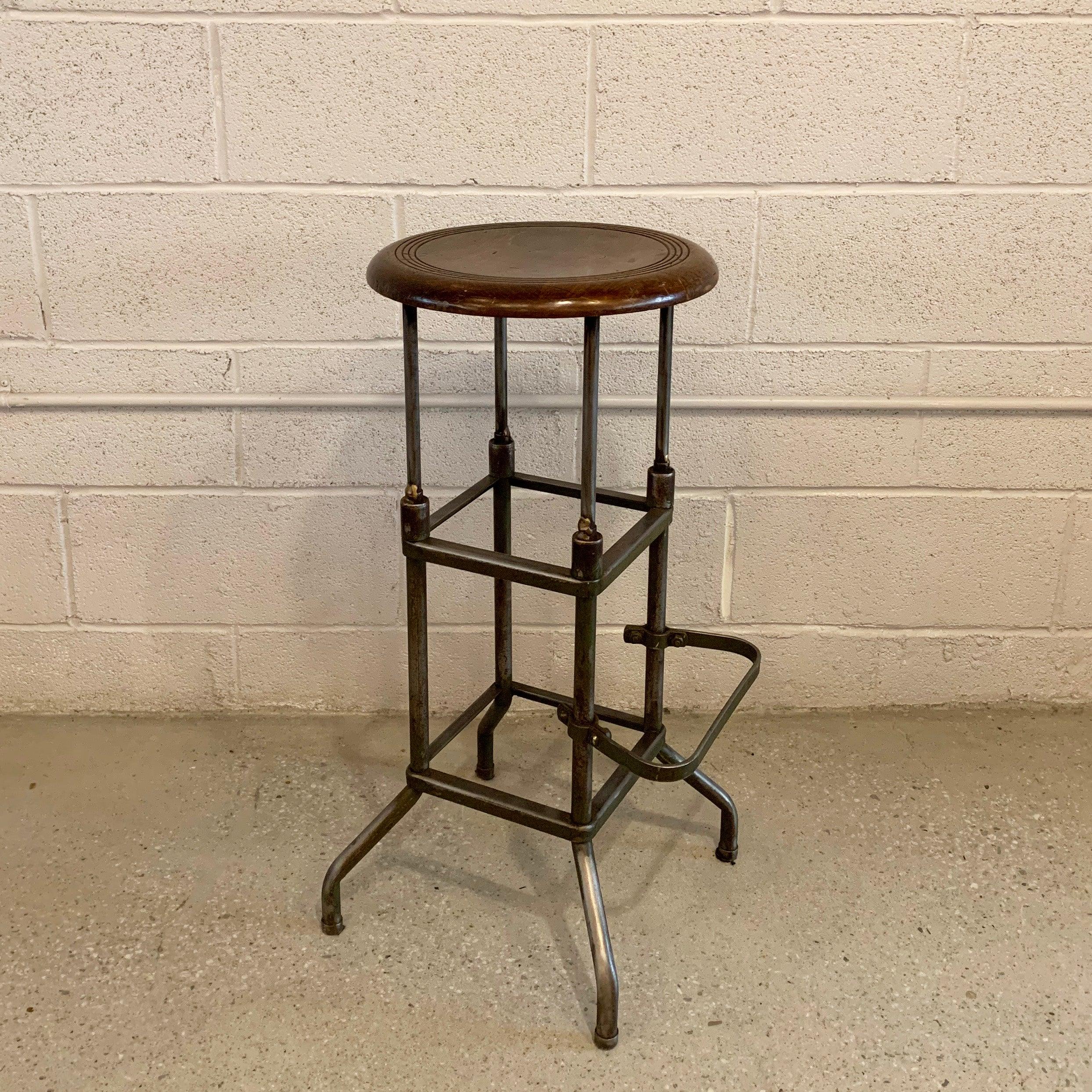 Industrial, early 20th century, drafting stool features a brushed steel base with footrest and a 14 inch diameter, round maple seat.
