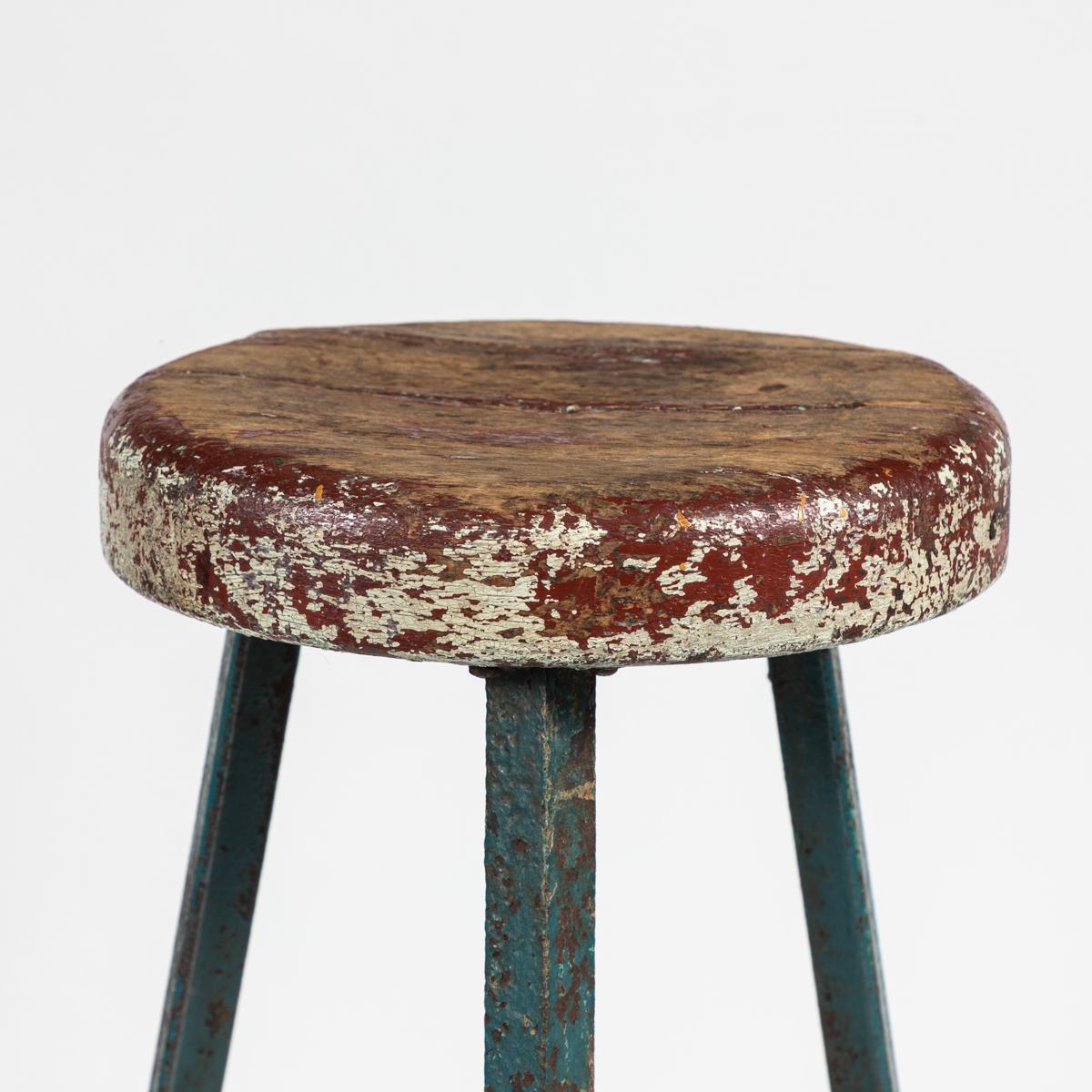 Early 20th century industrial metal stool with rustic wood seat from France.