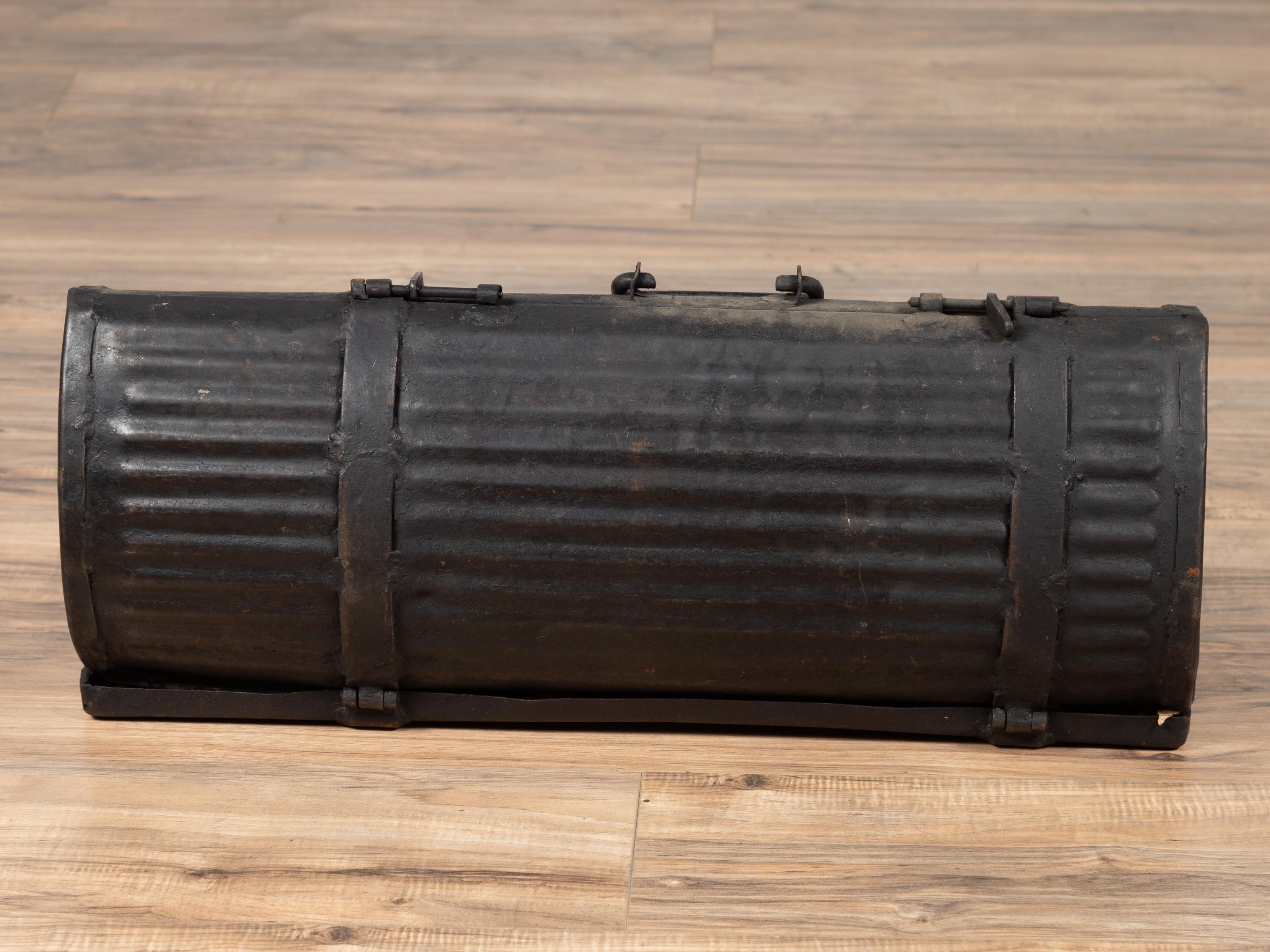 An antique rustic metal tool box from the early 20th century, found in India. Presenting a dark patina and ribbed surface, this antique metal tool box opens up thanks to small latches and both sides unfold around the central section. With its rustic