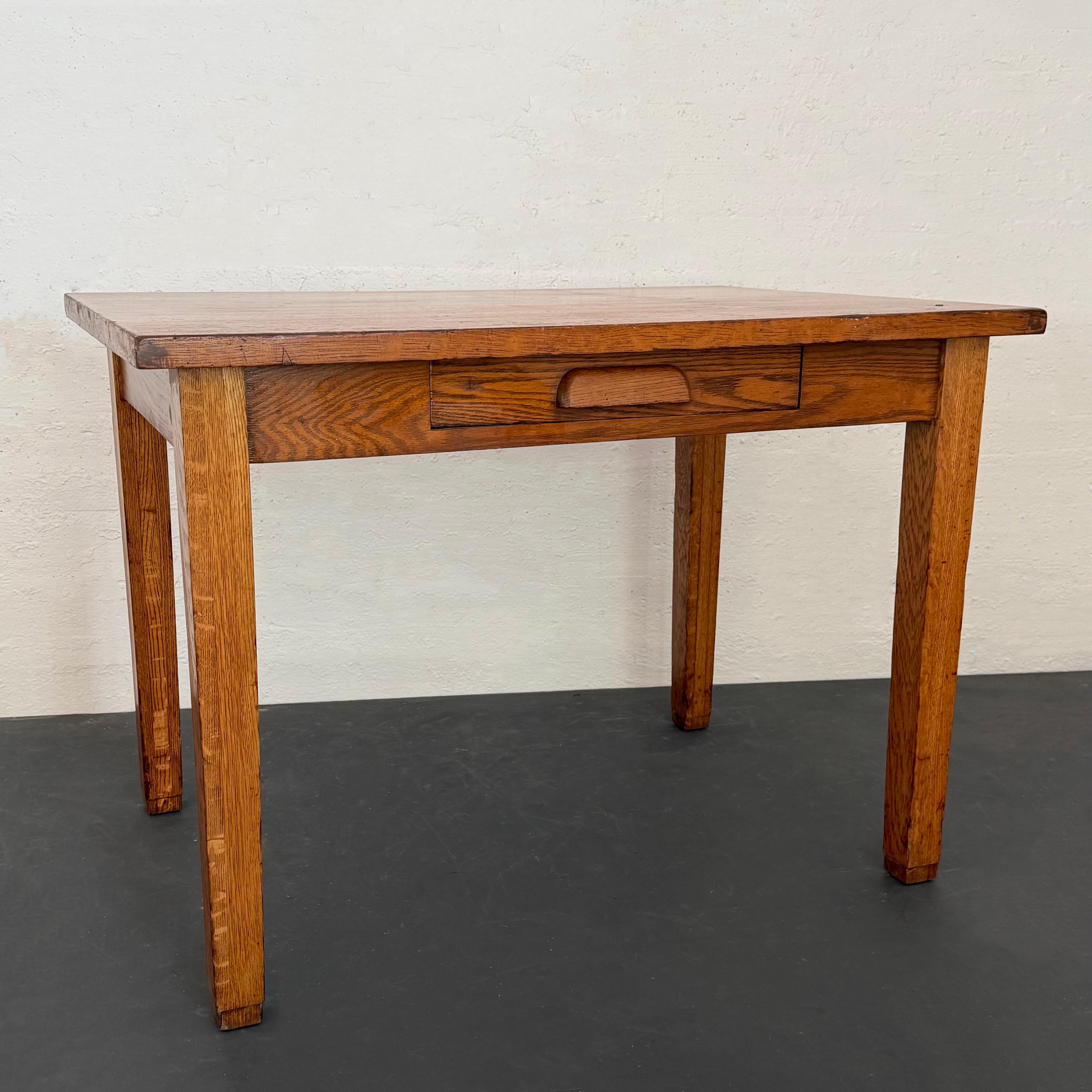 Ce bureau en chêne scié sur quartier, fabriqué par The Table Company au début du XXe siècle, est une pièce industrielle flexible à l'histoire riche qui peut être utilisée comme bureau, table de travail, table de salle à manger ou de cuisine. Il