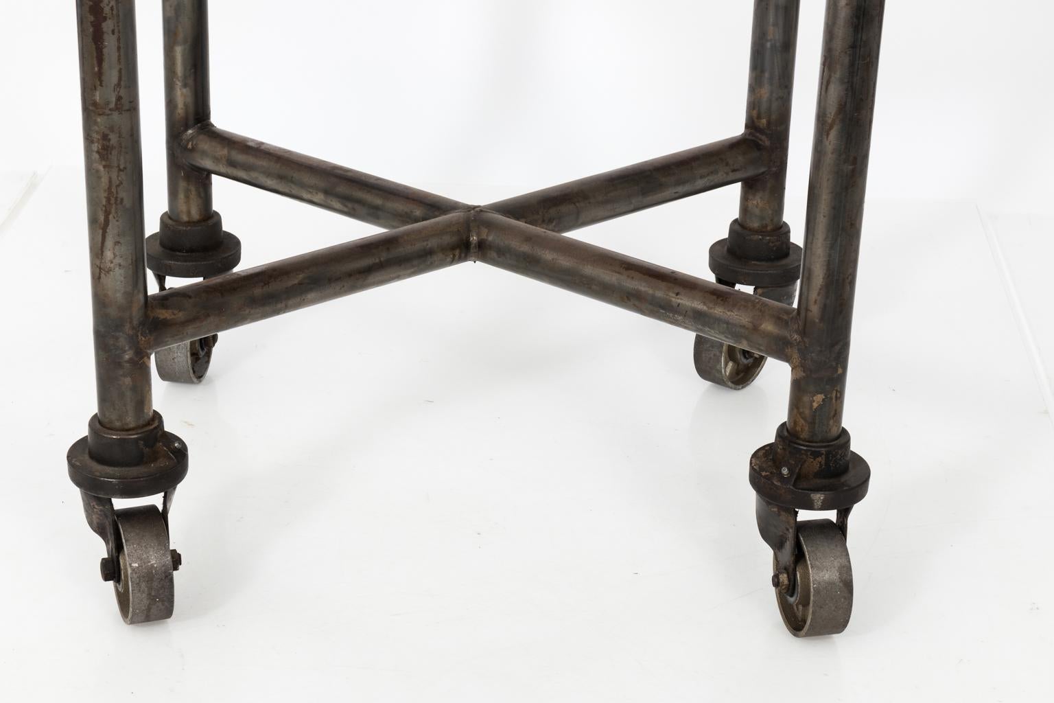 Early 20th century industrial steel side table on large castors.