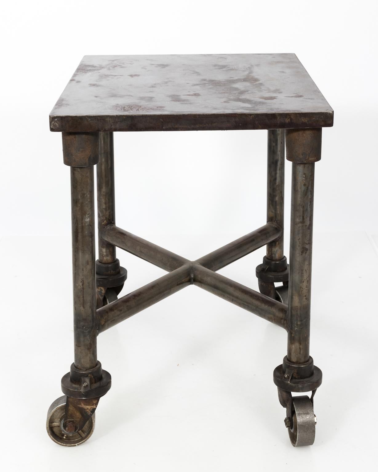 Early 20th century industrial steel side table on large castors.