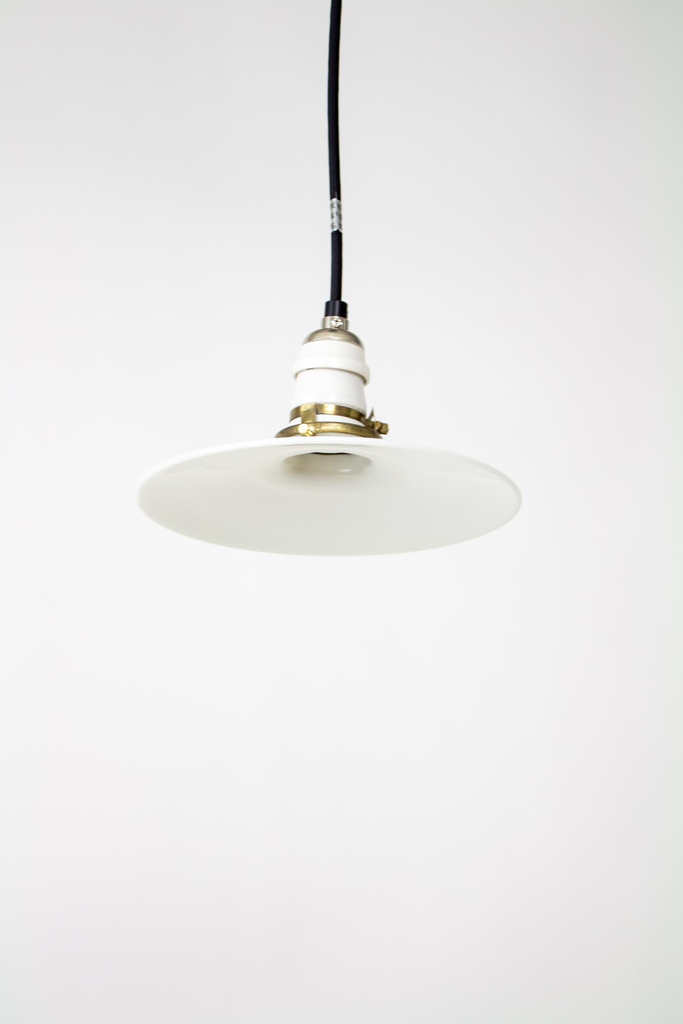 Early 20th century industrial white disk pendant. Black cord and canopy, porcelain antique style socket, antique clamp fitter and milk glass disk shade. Shown with Edison style bulb as a style suggestion, bulb is not included. Fixture is adjustable