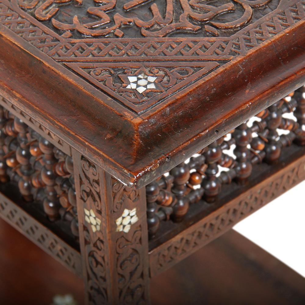 An unusual highly-carved two-tier Syrian table with mother-of-pearl inlay and finely-turned latticework details.
 
