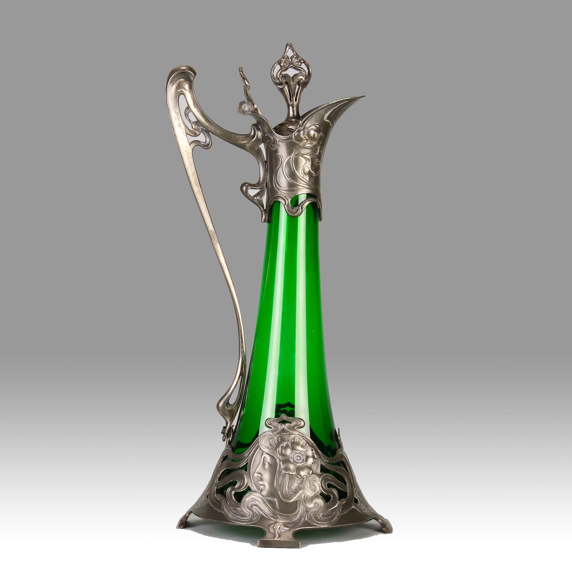 A very fine early 20th Century German WMF Art Nouveau Decanter the pewter plated body with green glass insert, decorated with roundel busts of Art Nouveau ladies with flowing hair and tendril design to applied handle and lidded stopper, stamped with