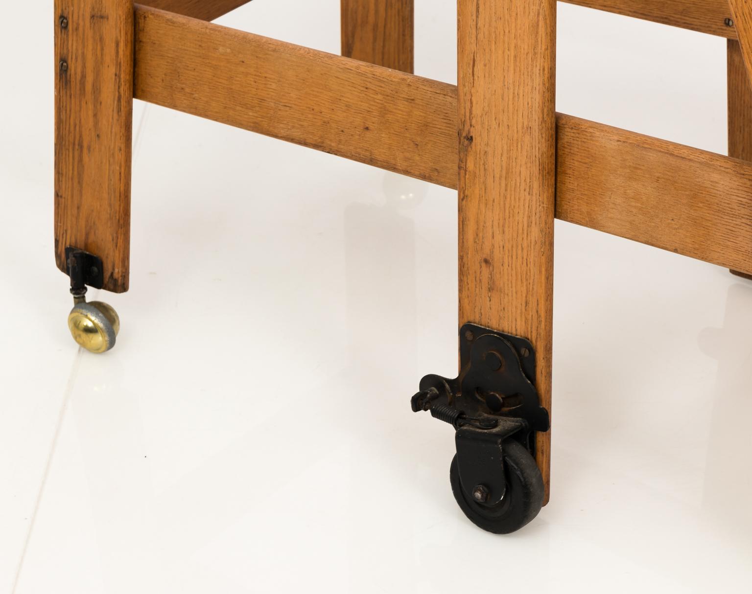 Early 20th century oak work or library ladder with iron railing and four wheels. Very stabile.
 