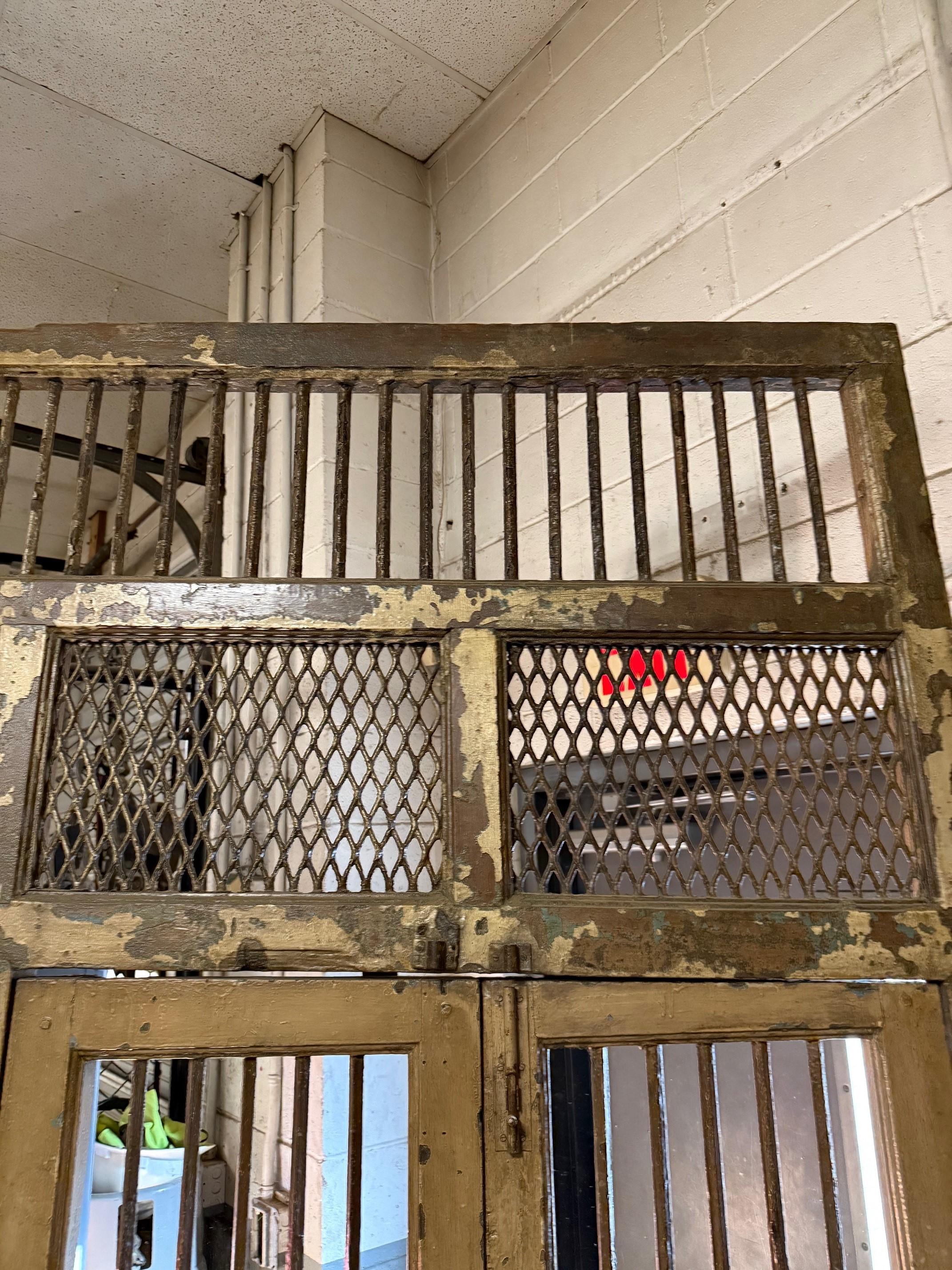 Large Early 20th Century antique wall panel or divider with a small pair of doors with iron bars and metal mesh. This large panel was salvaged in India and was cleaned and sealed years ago for a great distressed look. The doors swing open with a