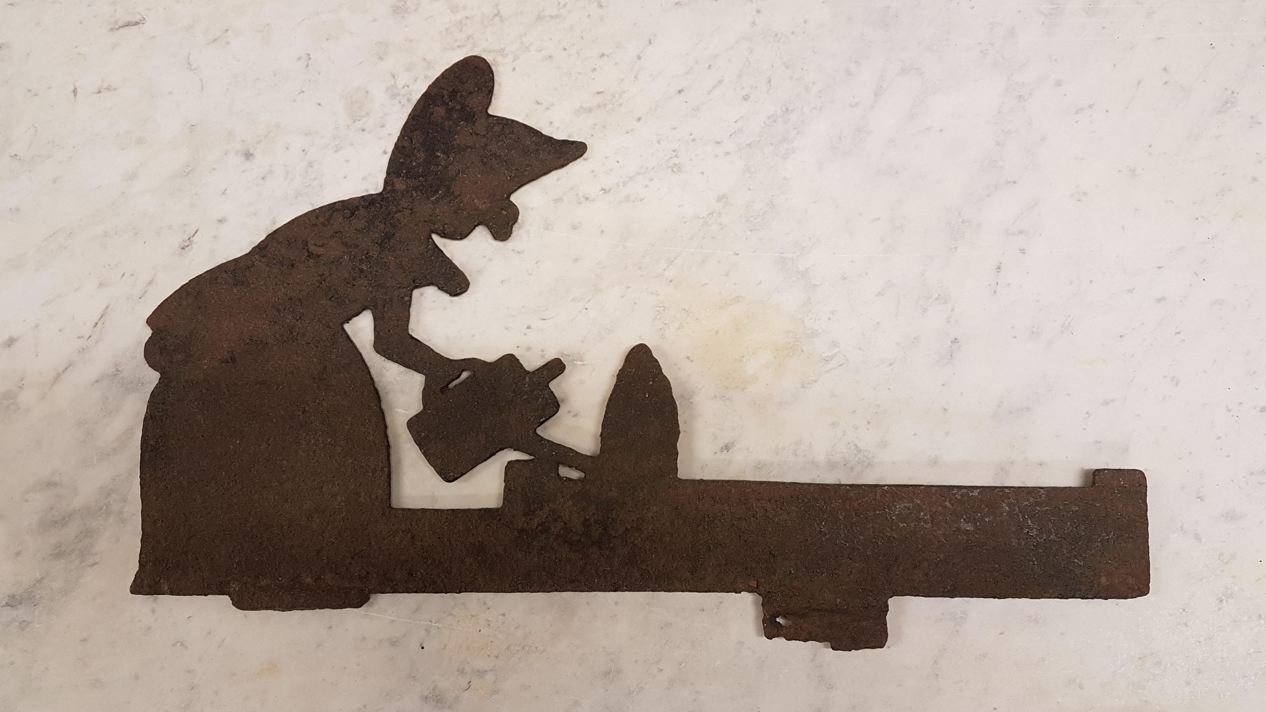 A lovely early 20th century Folk Art iron Silhouette of a woman watering her bush, this was originally at boot scrape to be found at the door or a farm house and would have been mounted to either a large piece of stone or set in concrete. The fixing