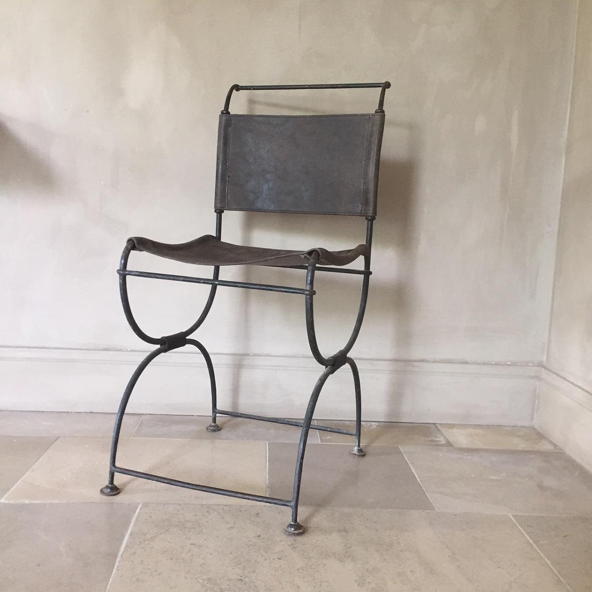 A lovely elegant iron and leather chair. Dating from the early 20th century this type of chair is often referred to as campaign chair or officers chair. The leather is in good condition and the overall look of the chair goes well in every