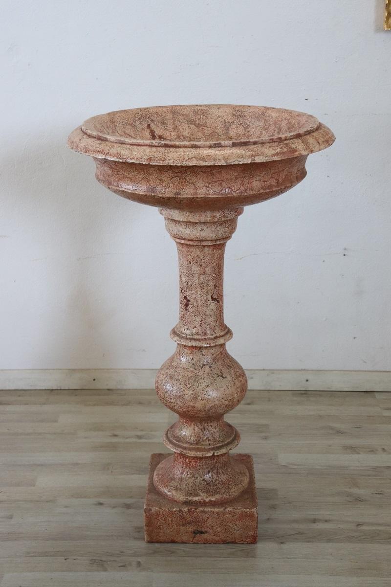 Rare Italian antique hand carved stone tub holy water font. Its style is classic with a circular basin with a molded edge, supported by a multi-order turned baluster and a square foot. the stone was enamelled in red to give a marble effect. Signs
