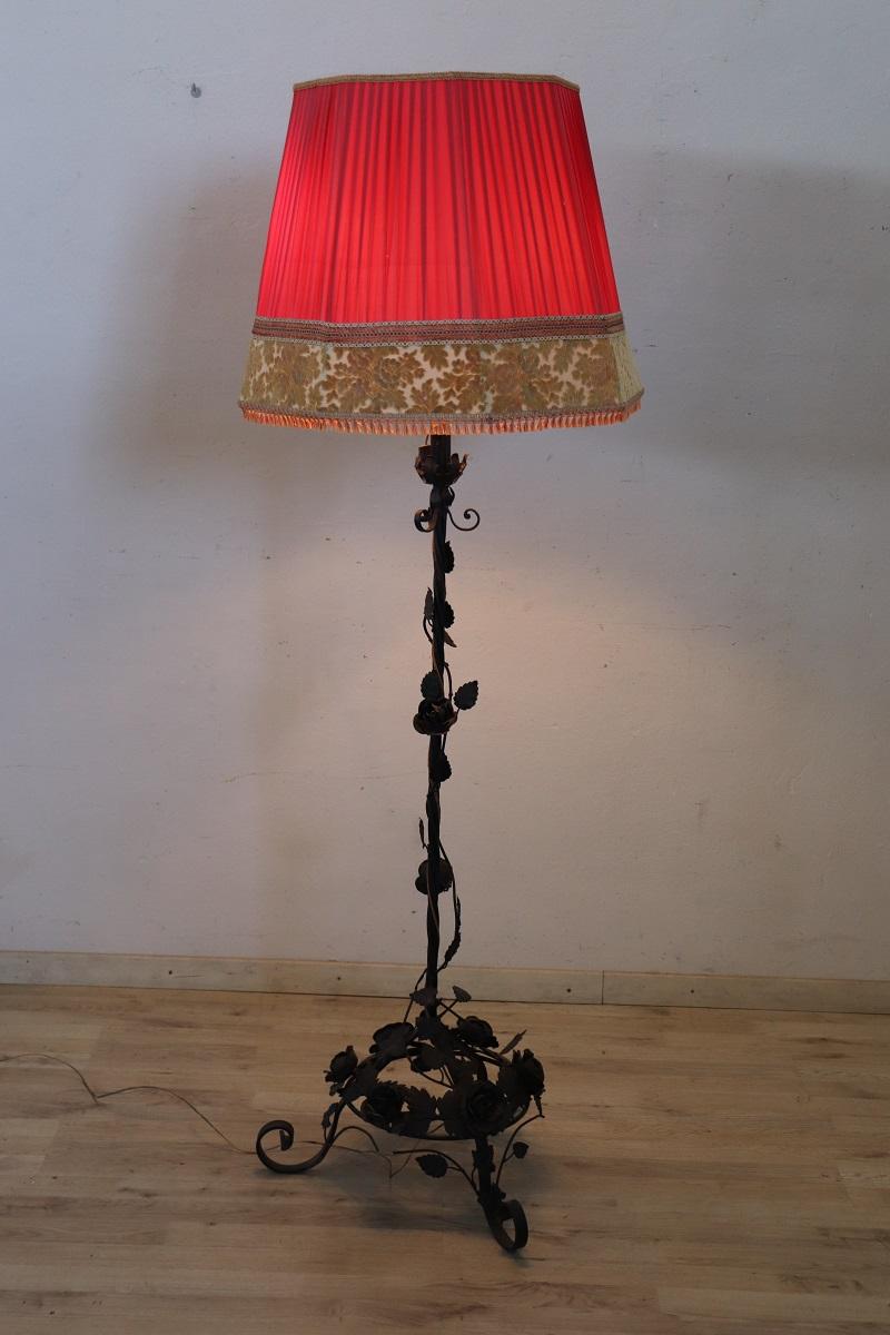 Beautiful early 20th century Art Nouveau iron floor lamp. The body of this lamp is a true work of art in iron. Characterized by a rich floral decoration with many large roses. A beautiful original lampshade in pleated red fabric. The iron has a nice