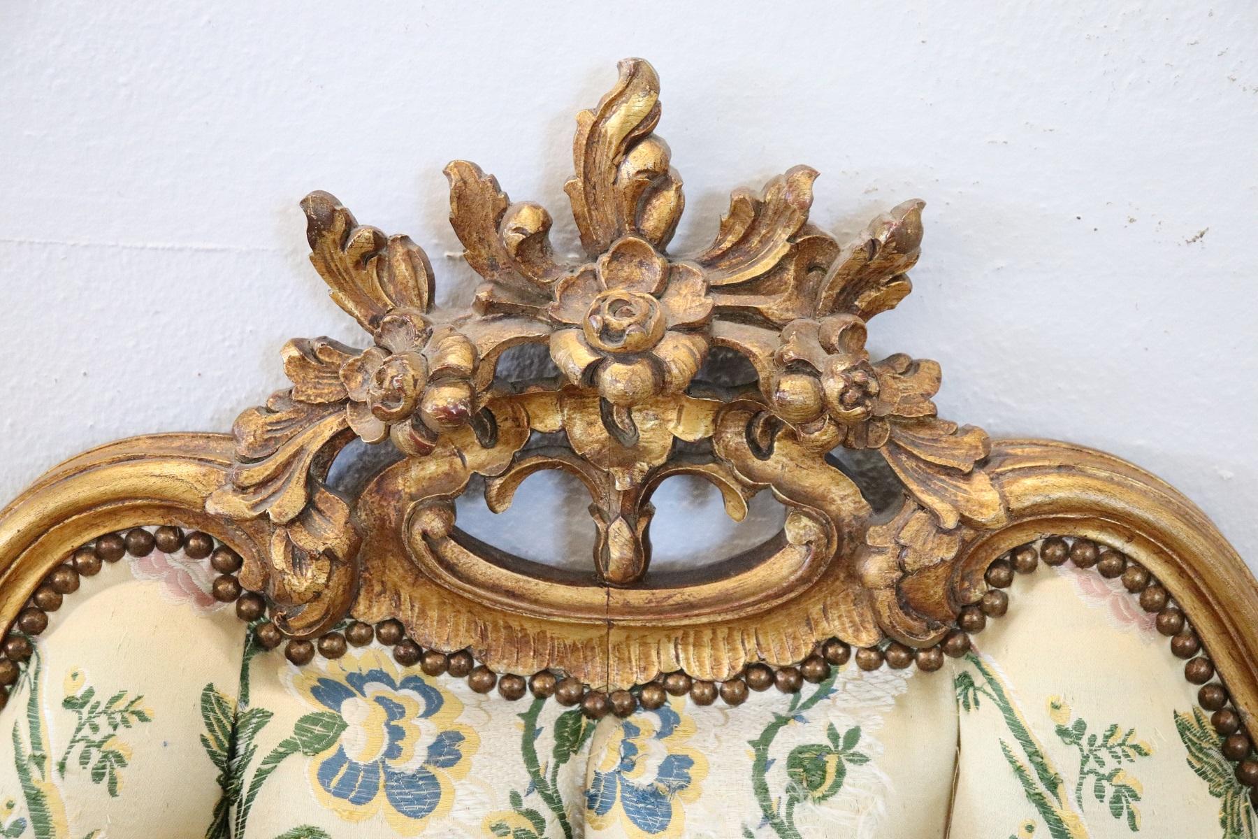 Delicious Italian Baroque style double bed, 1920s. Featuring finely carved wood with curls and swirls enriched with stunning gold leaf gilding. Capitonnè padding with elegant fabric with floral decoration. In good condition, the gold has acquired