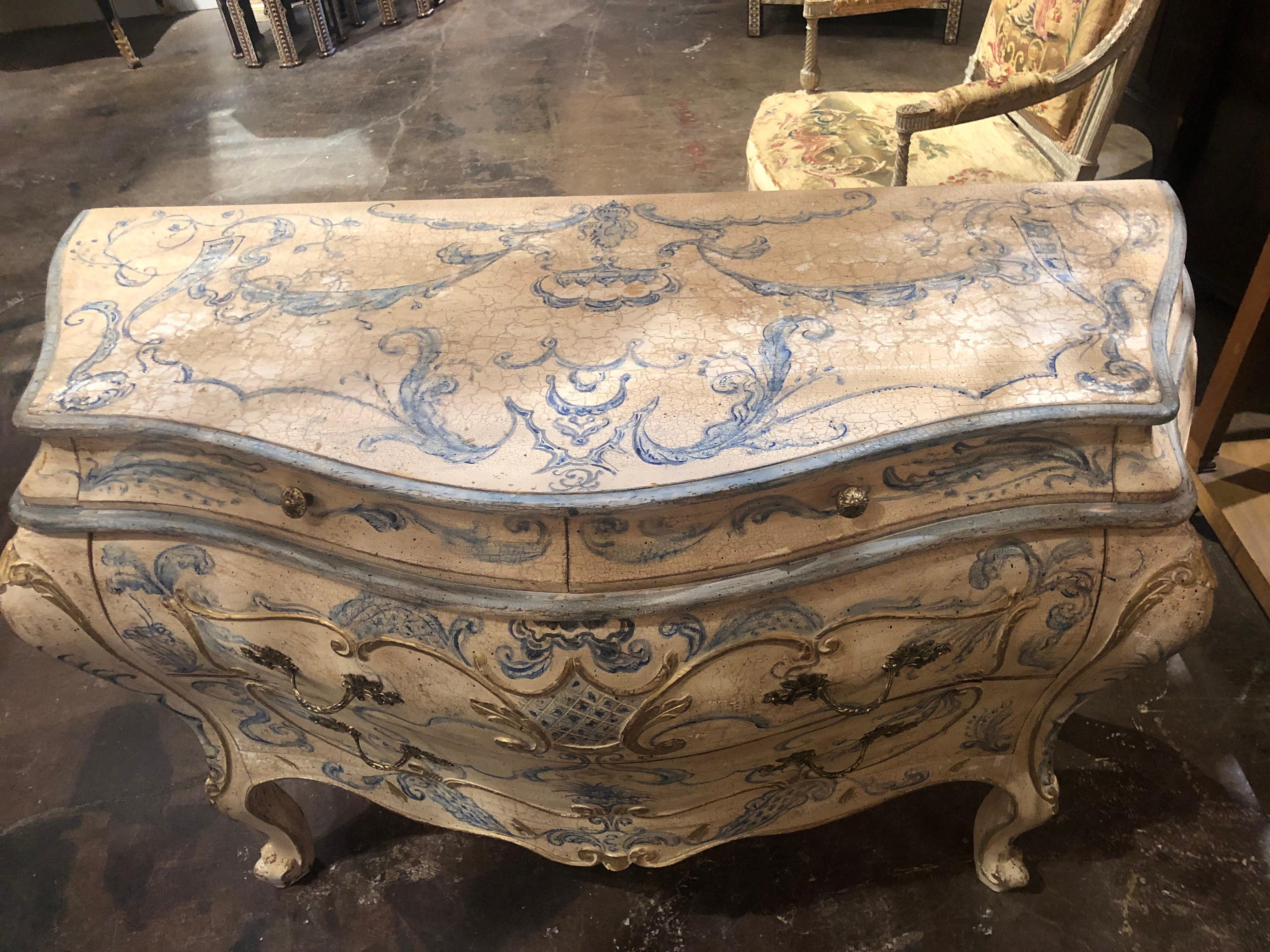 Lovely Italian bombe' shaped hand painted commode. Painted images of leaves, scrolls and flowers in an indigo blue color. The commode also has touches of gold gilt and the base color has a very nice patina as well, a truly unique piece!
