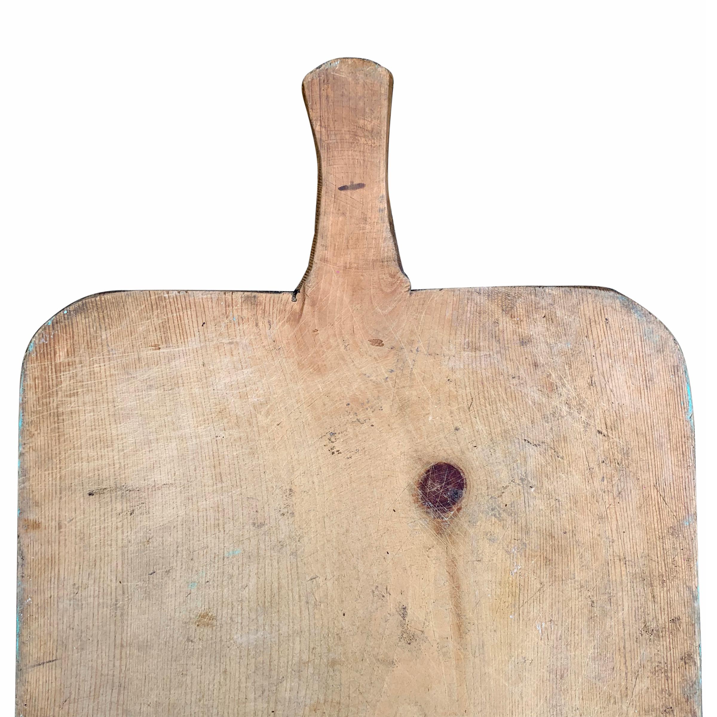 A wonderfully worn early 20th century Italian pine peel used in the bread baking process, with a beautiful patina. All that’s missing is a selection of cheeses, prosciutto, and your guests. Also perfect for use as a chopping block.